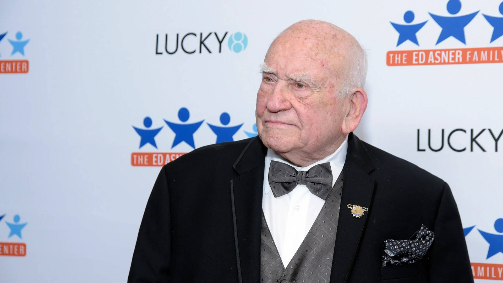 Legendary Actor Edward Asner Against a Blue and White Background Wallpaper