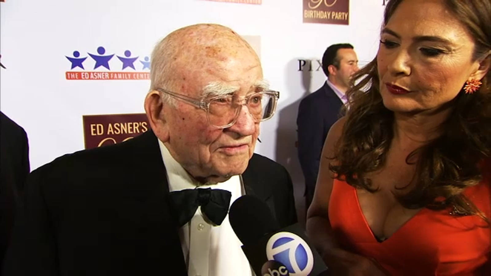 Legendary Actor Edward Asner Engaging in a Friendly Conversation with a Reporter Wallpaper