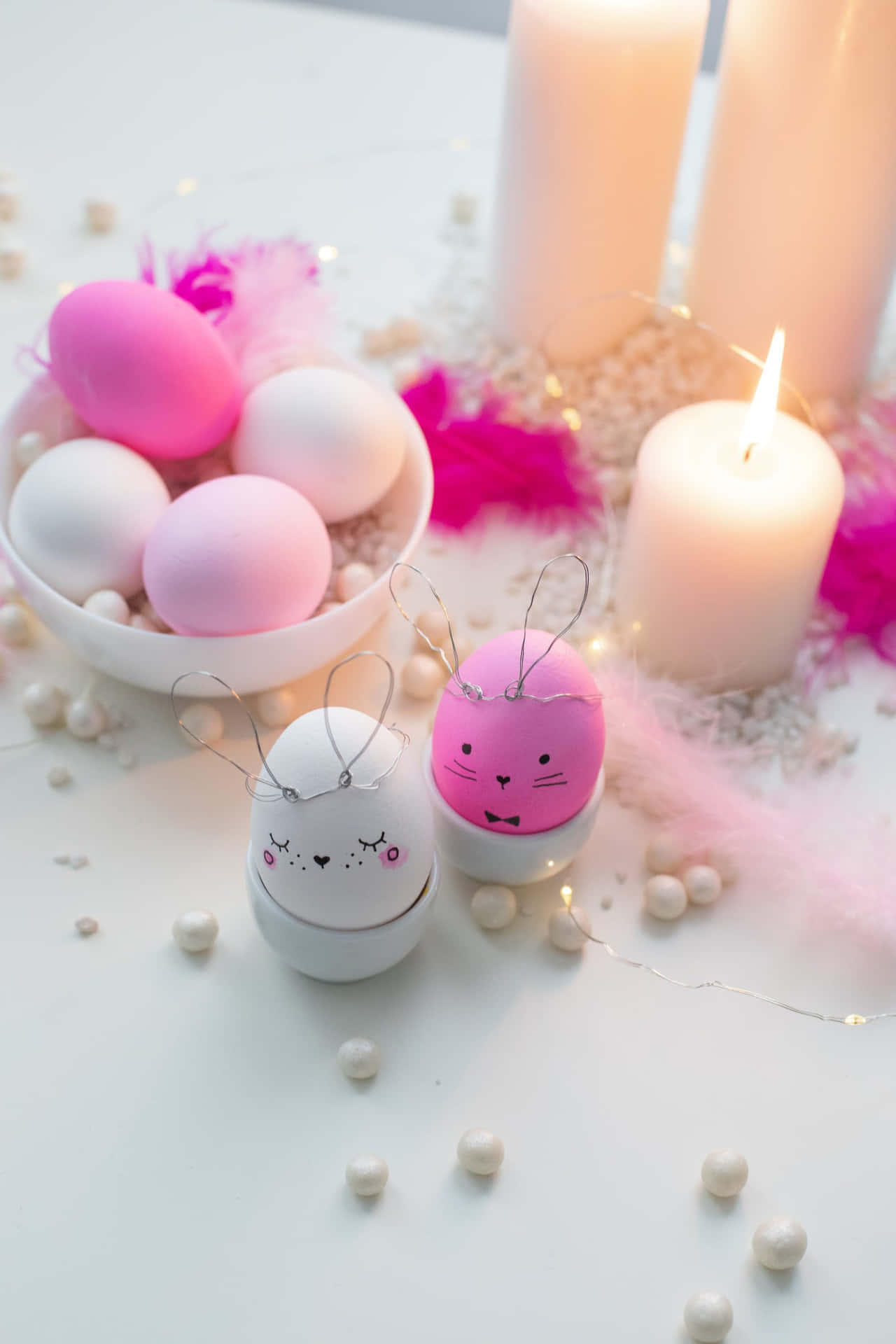 A Table With Pink And White Eggs And Candles