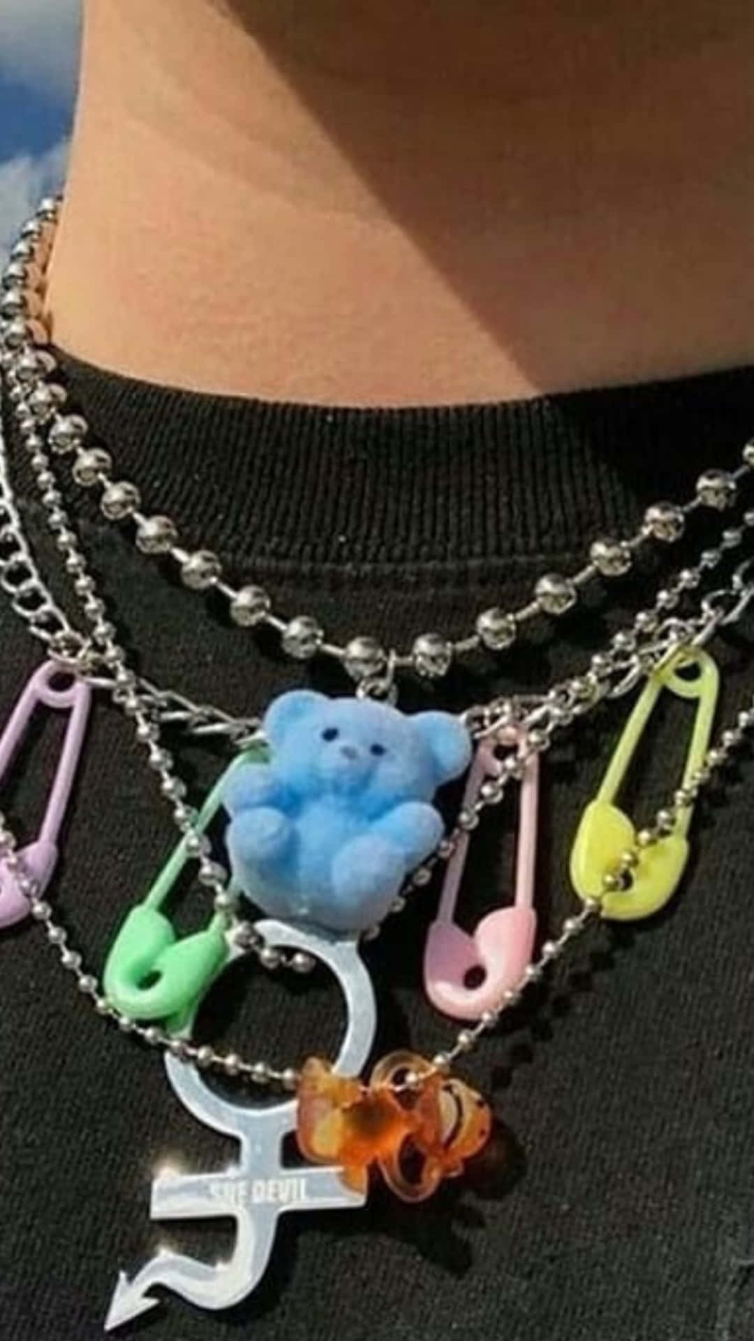 A Person Wearing A Necklace With Many Different Charms Wallpaper