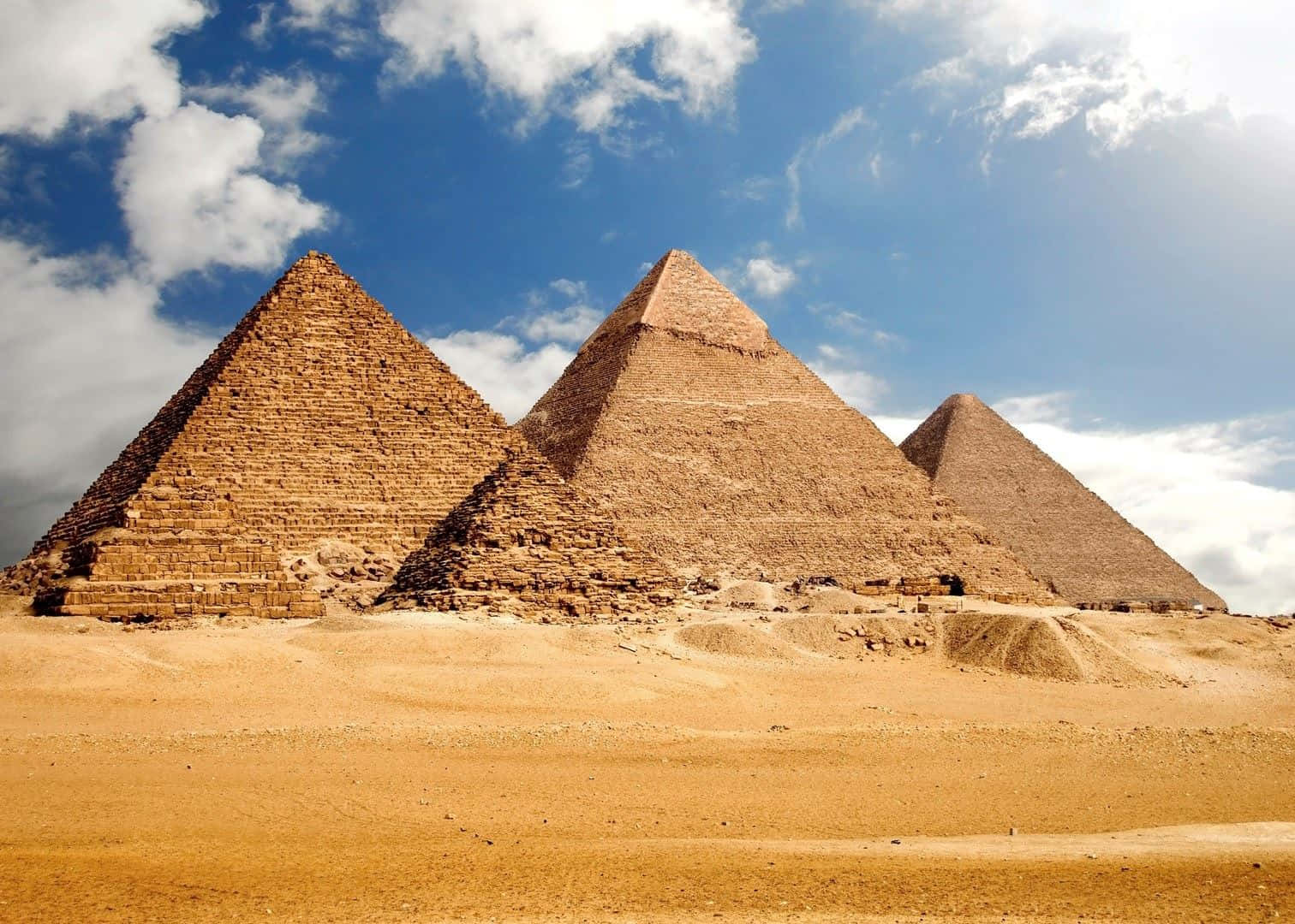 Three Pyramids In The Desert With A Blue Sky