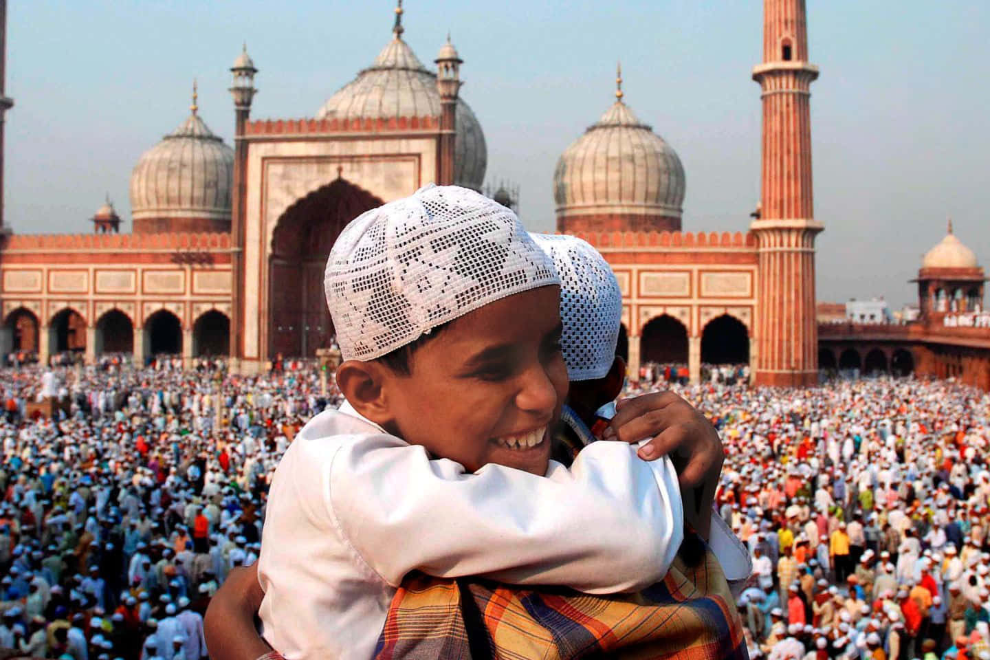 A Boy Is Hugging A Boy In Front Of A Mosque