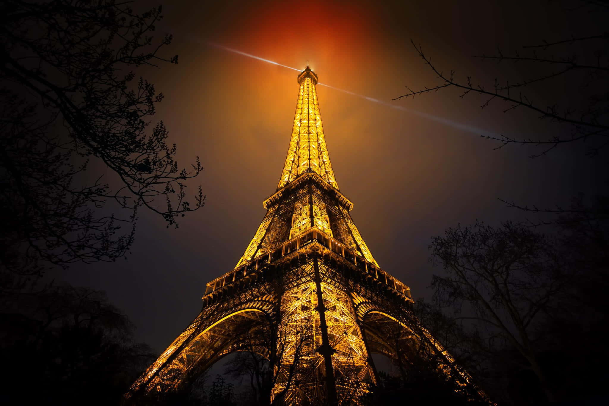 Enjoy the romantic city lights of Paris from the Eiffel Tower at night.