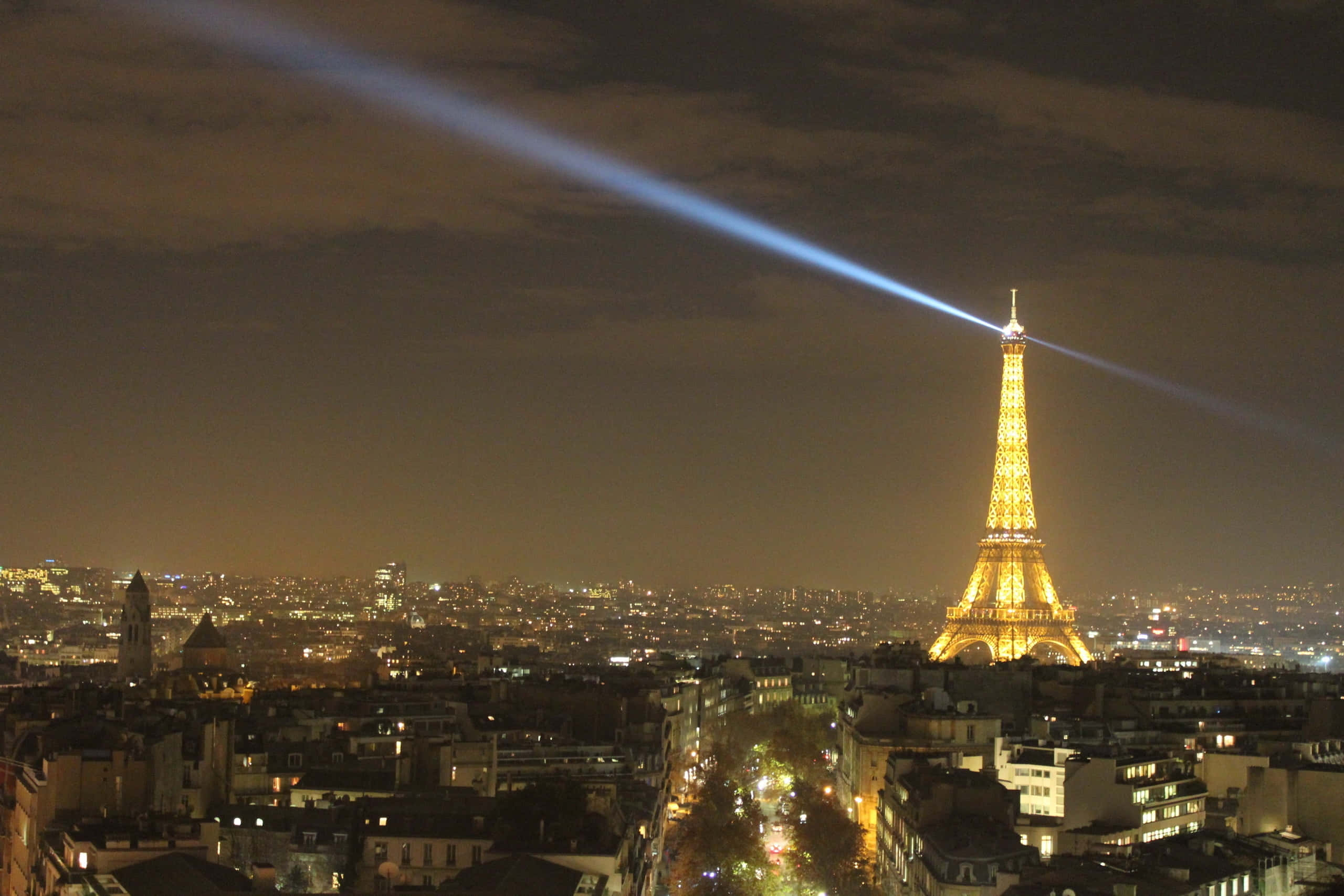 The Eiffel Tower sparkles in the night sky over Paris