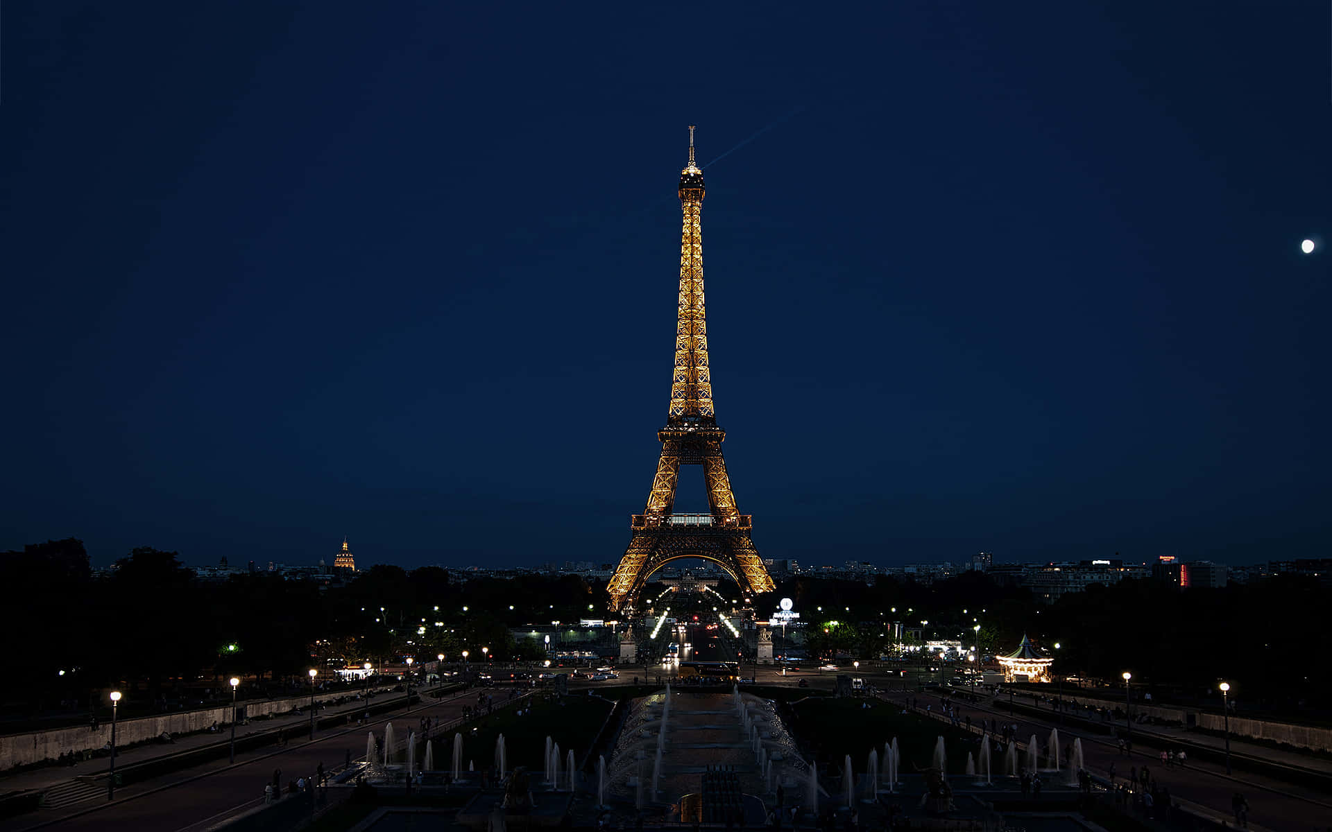 The Eiffel Tower at night lights up the sky with a golden glow.