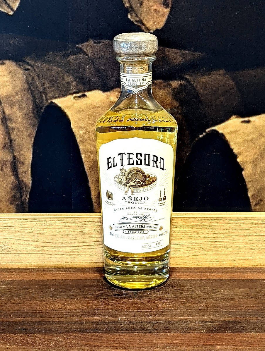 El Tesoro Añejo Gold Tequila Bottle Displayed on Rich Wooden Surface Wallpaper