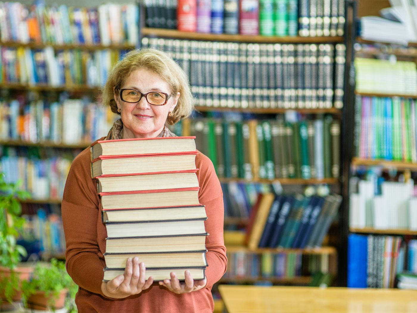 Elderly Librarian Holding A Book Wallpaper