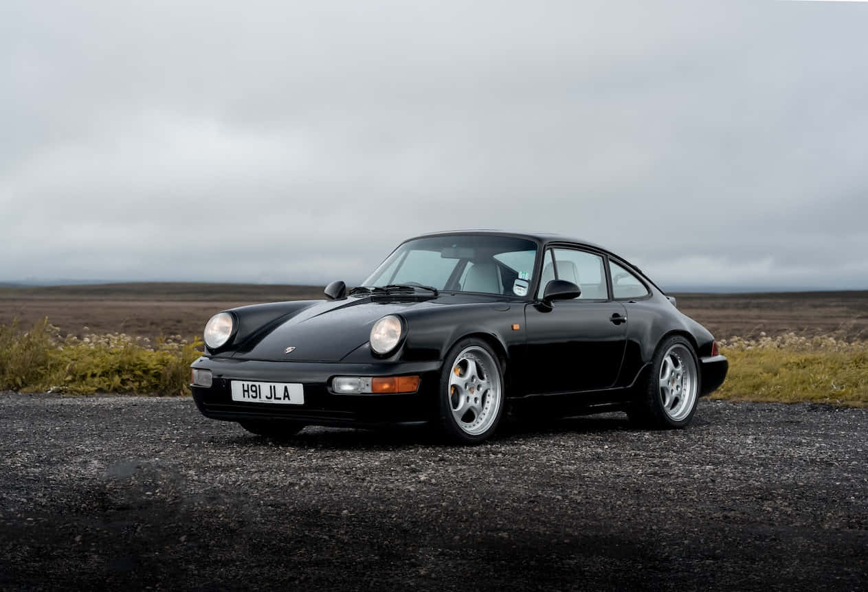 Elegance In Motion: Porsche 964 In A Scenic Environment Wallpaper