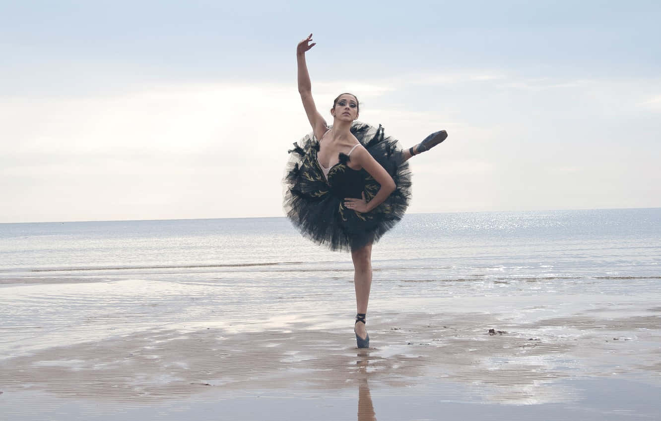 Elegant Ballerina In Motion Against A Dramatic Black Background Wallpaper