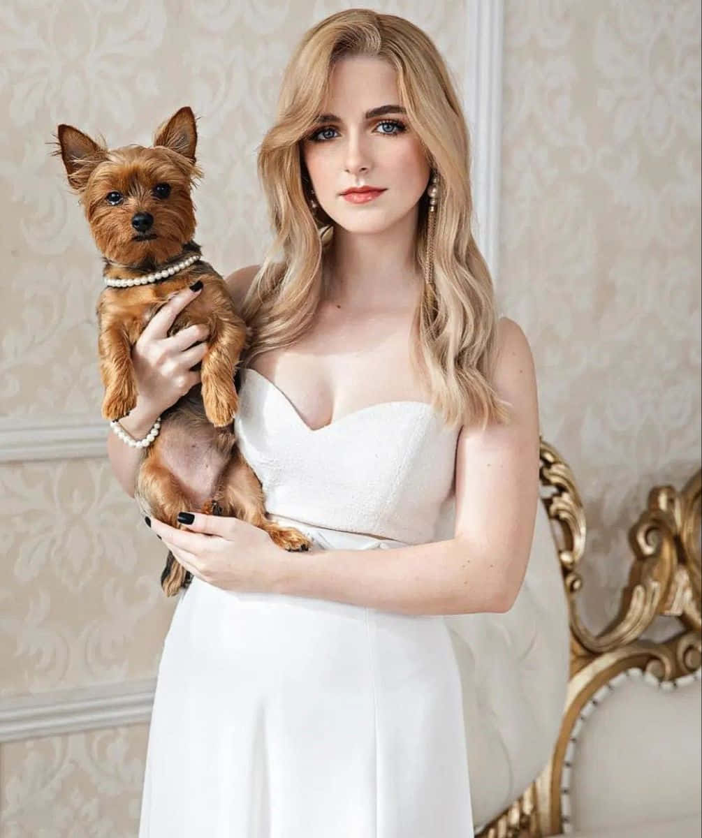 Elegant Blonde Woman Holding Terrier Dog Wallpaper