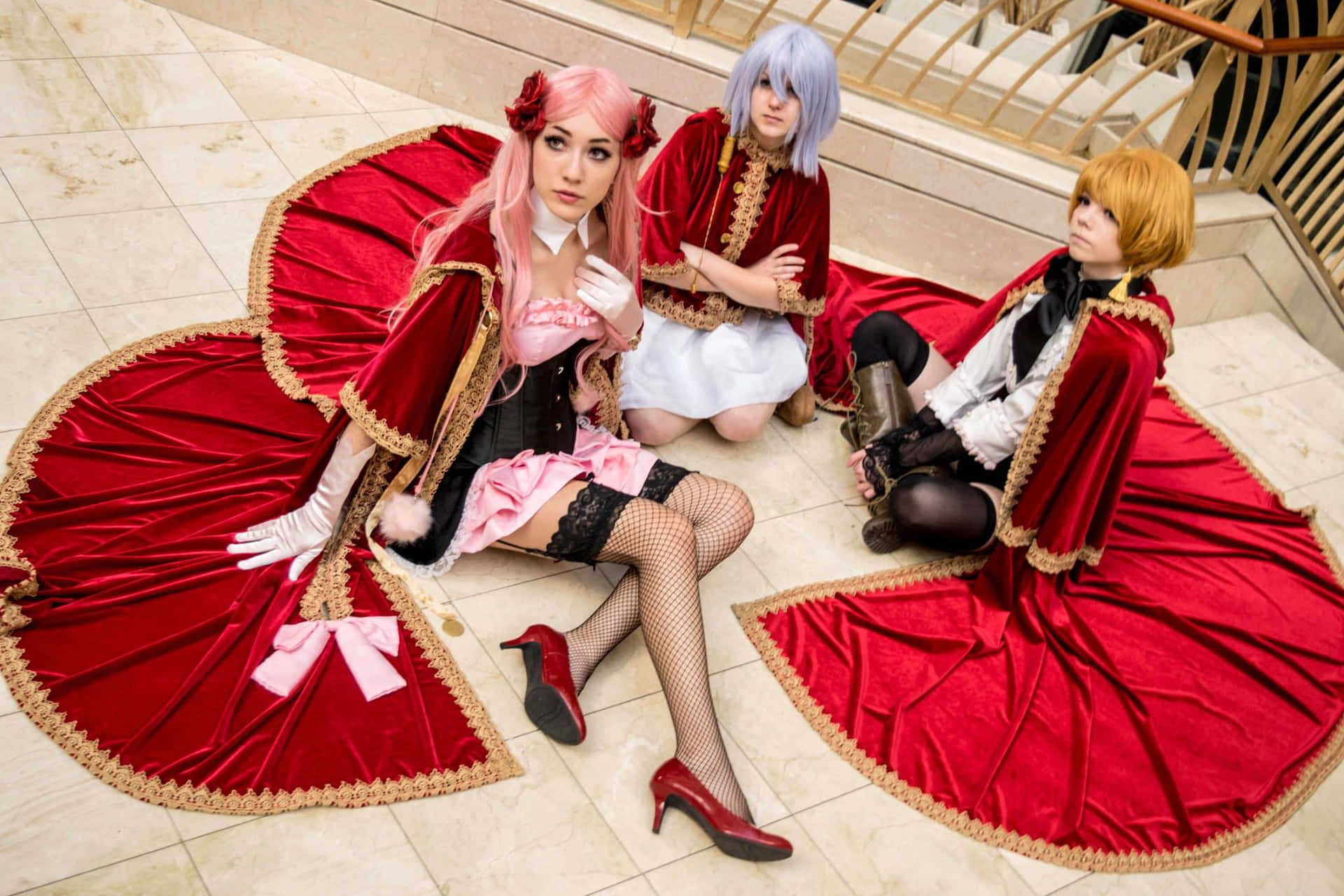 Elegante Cosplay Trio In Rode Capes Achtergrond