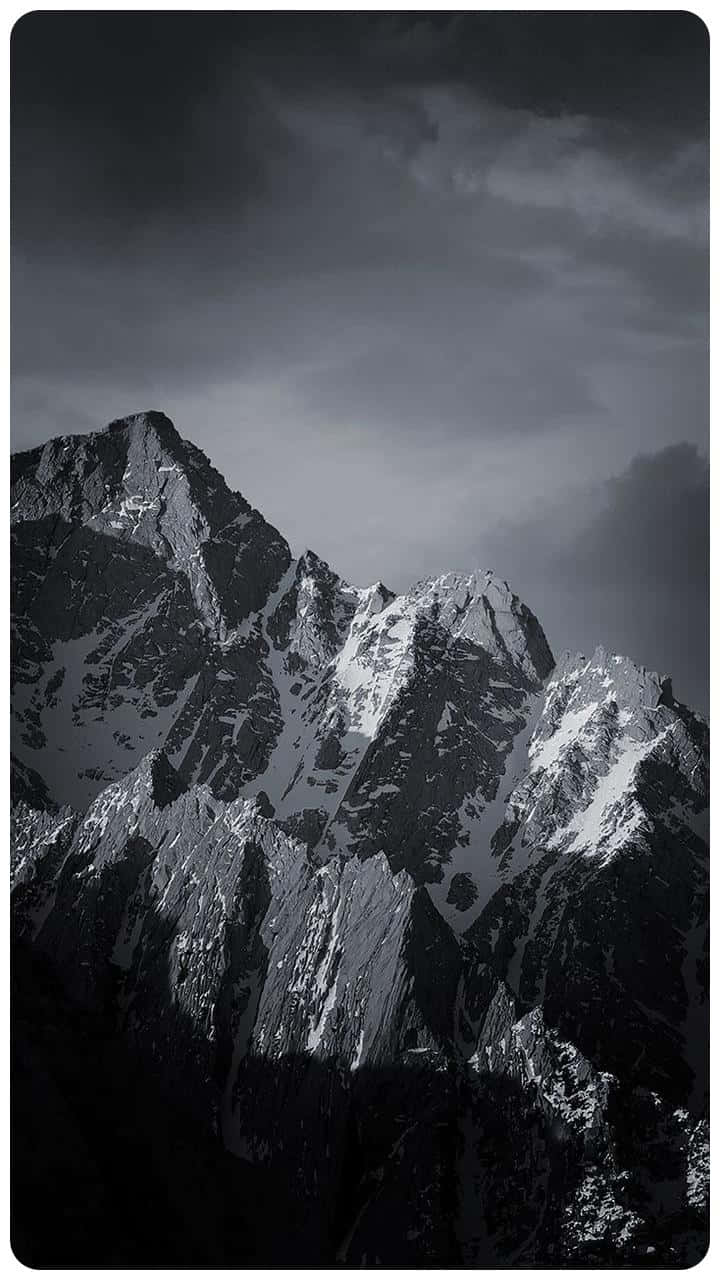 A Black And White Photo Of Mountains With Snow On Them Wallpaper