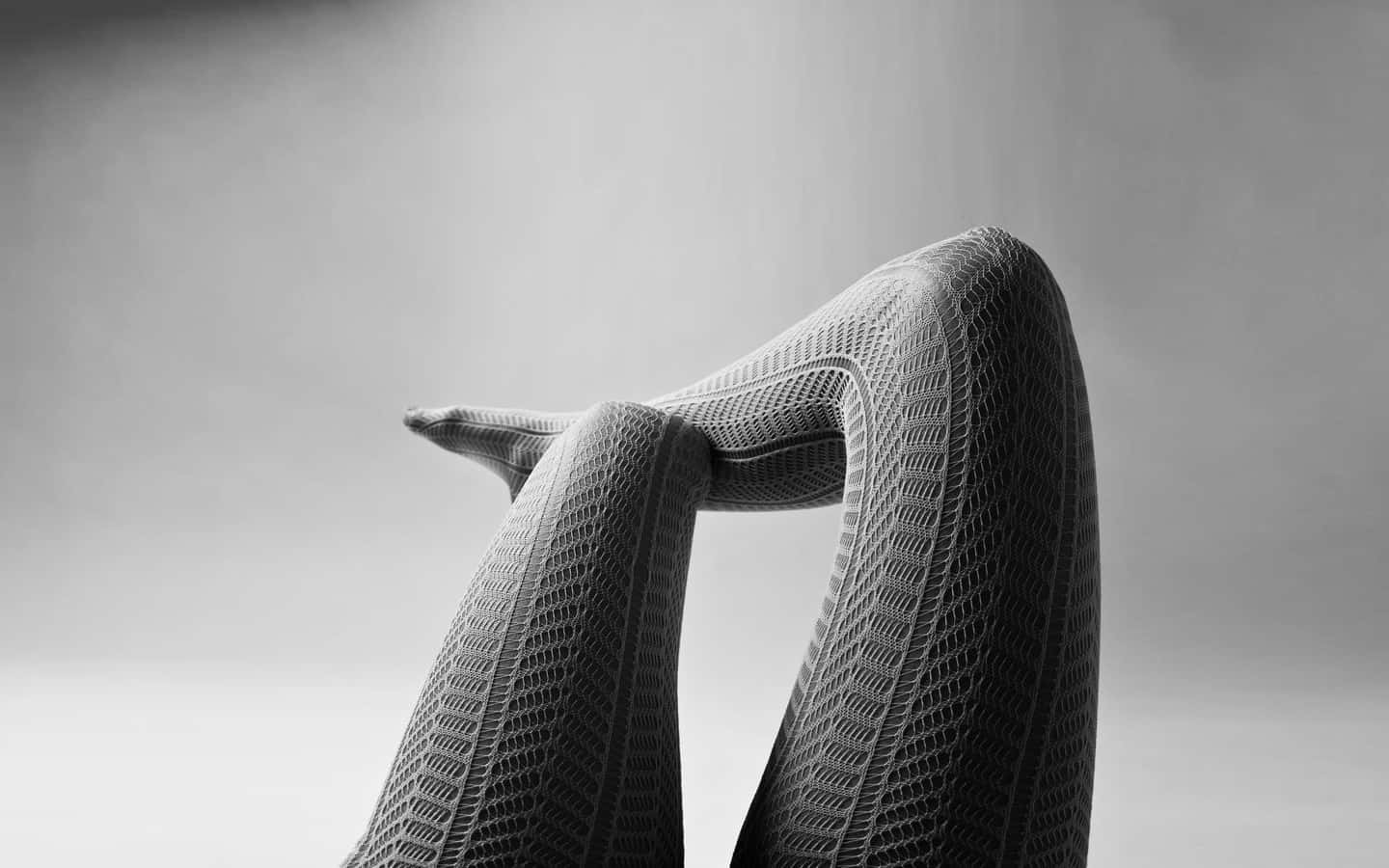 Elegant Legsin Fishnet Stockings Wallpaper
