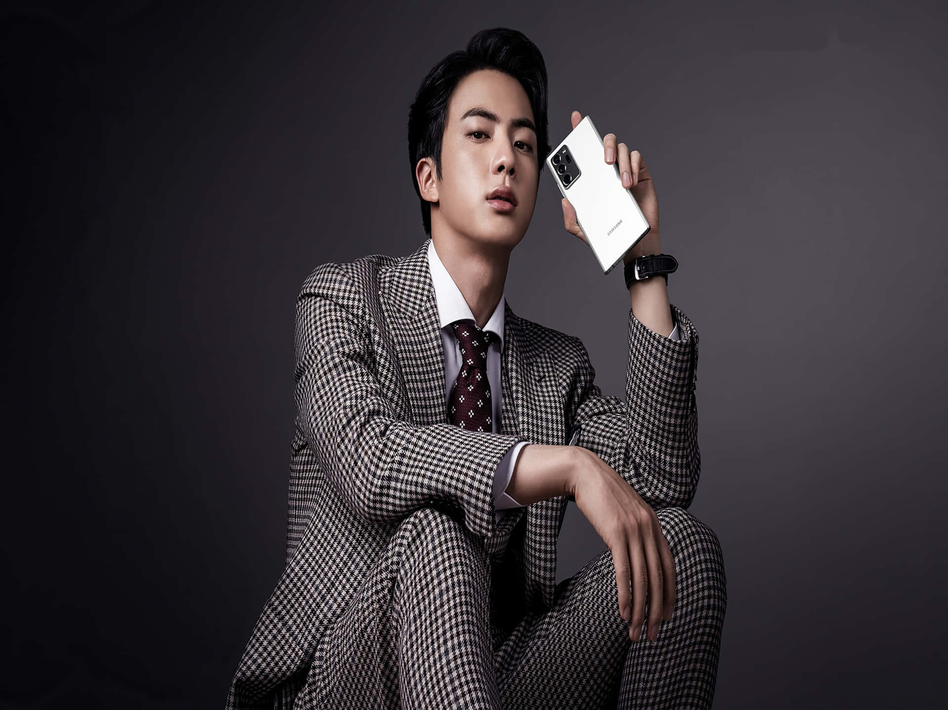Elegant Man Holding Smartphone Wallpaper