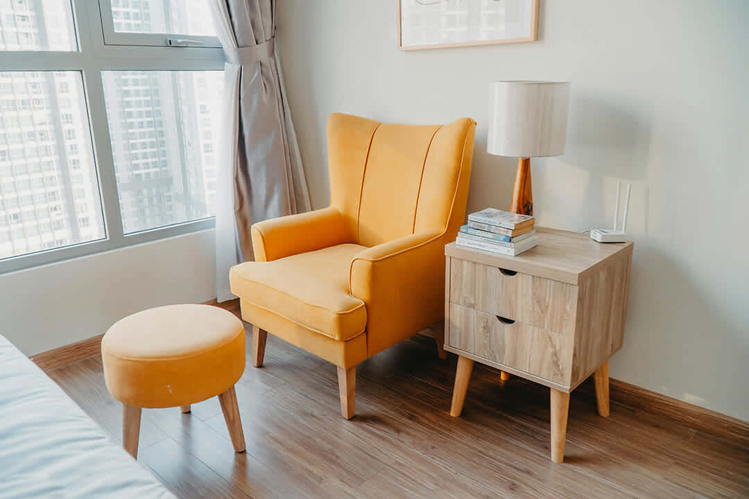 A Yellow Chair And Ottoman In A Bedroom