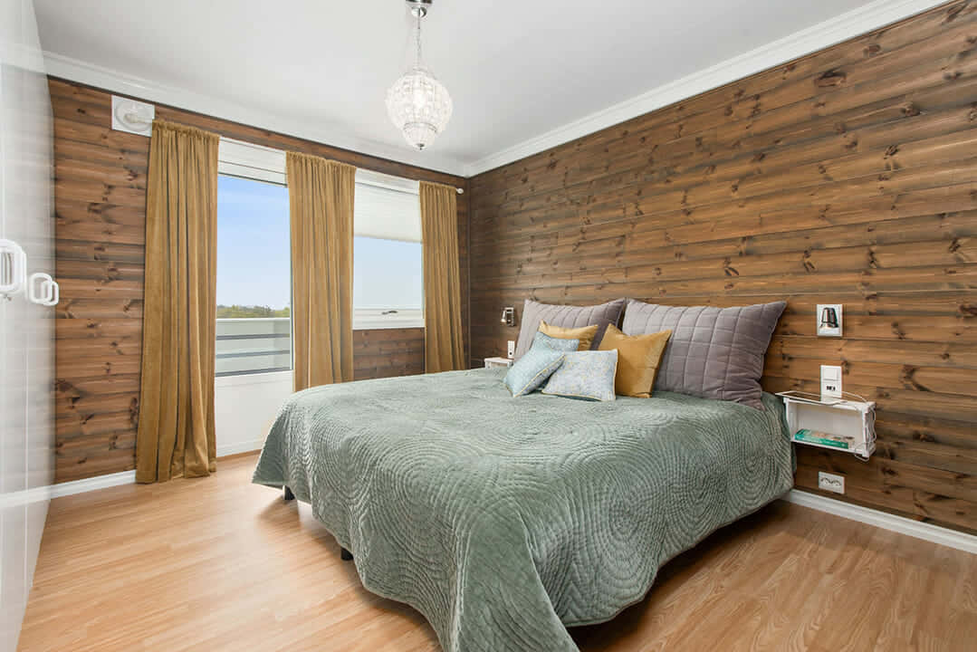 A Bedroom With Wood Paneling And A Bed