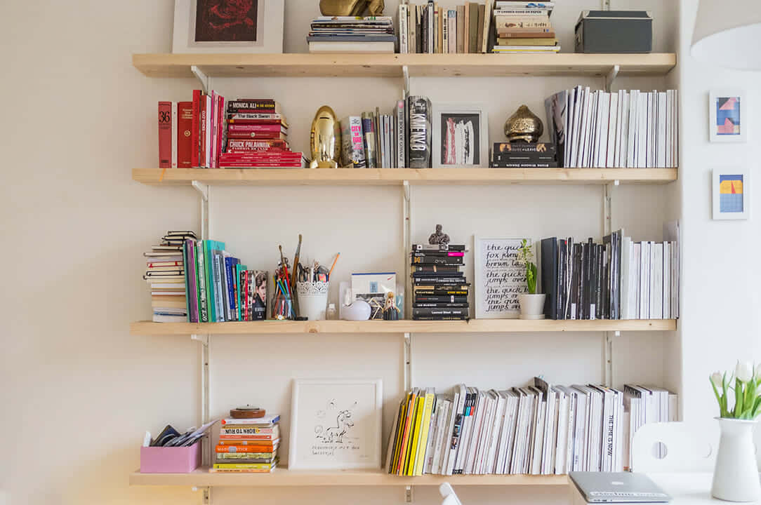 A White Shelf With Books And A Desk