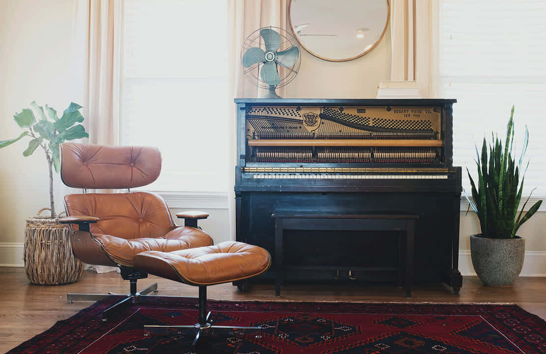 A Living Room With A Piano And Chair