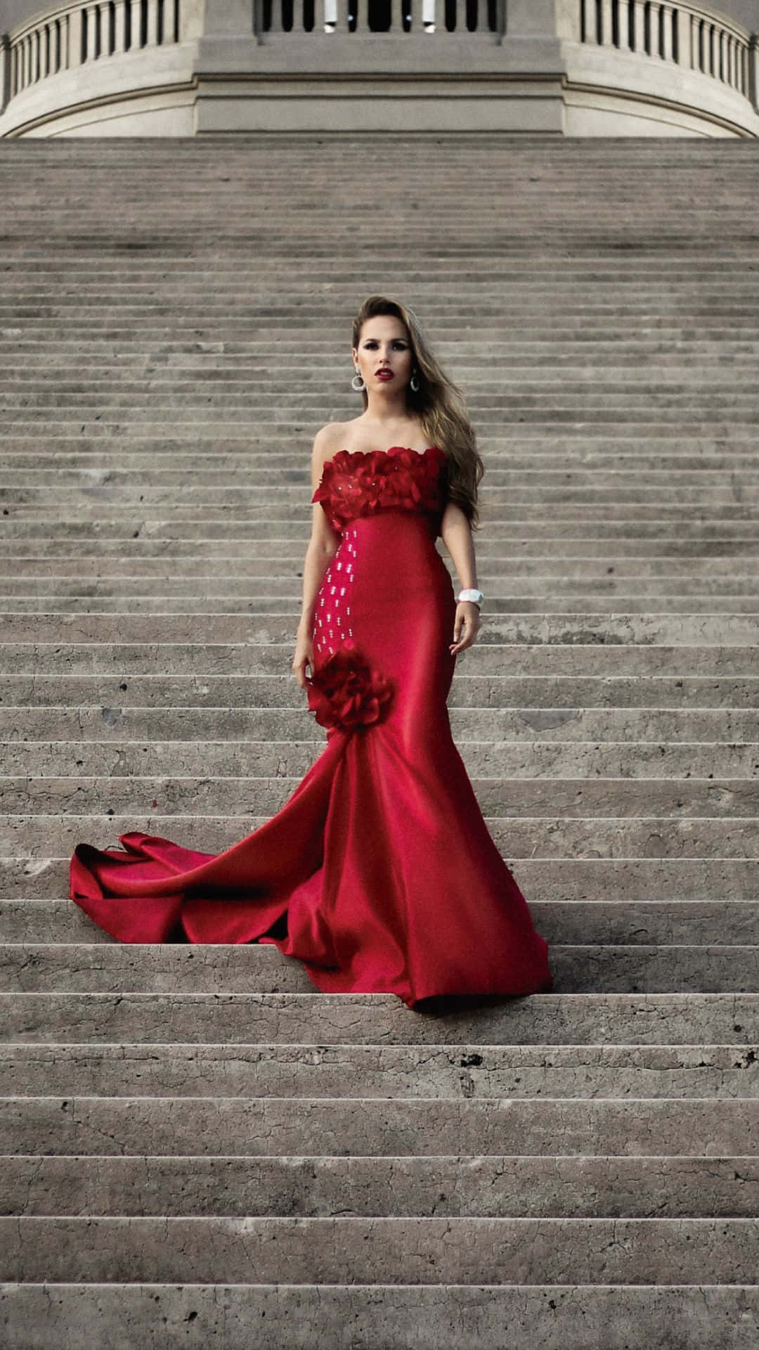 Elegant Red Gown Staircase Pose Wallpaper
