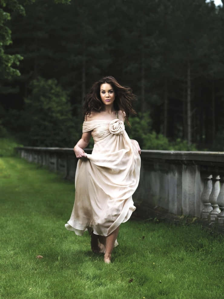 Elegant Womanin Beige Dress Outdoors Wallpaper