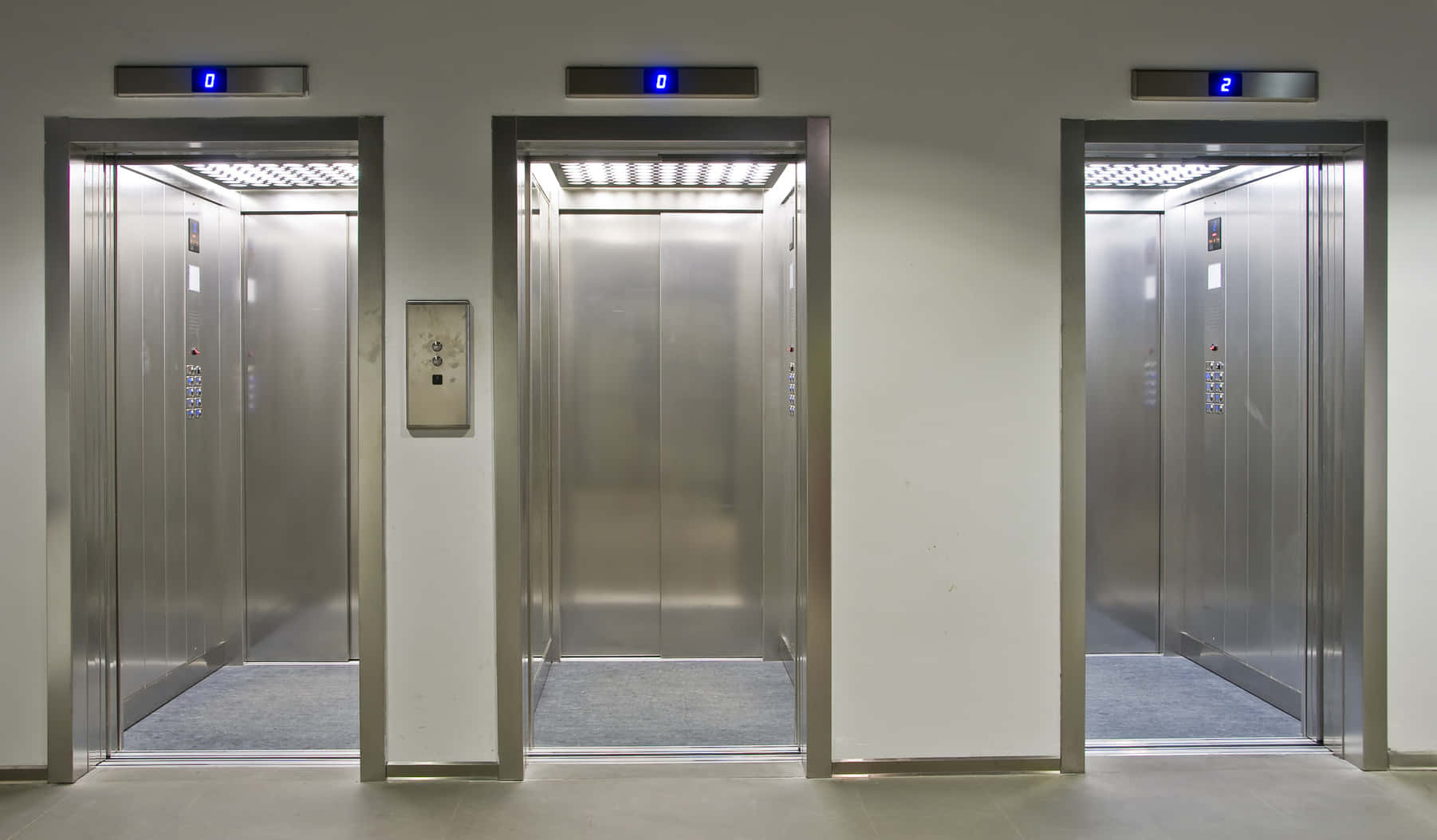 Four Elevators In A Building With Blue Lights