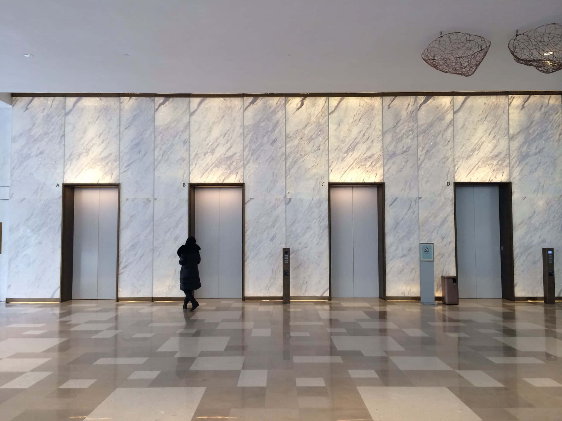 A Person Walking Through A Lobby With Marble Floors