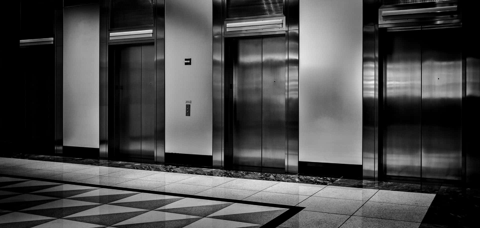 Black And White Photo Of Elevators In A Building