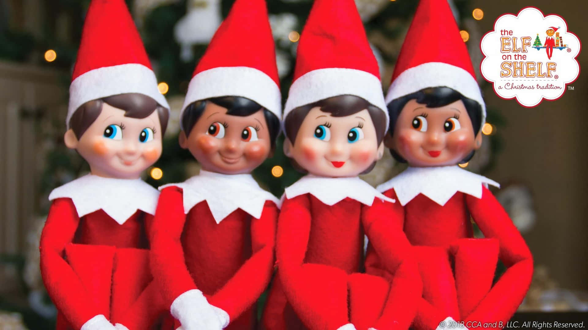 Three Elf Dolls Are Sitting In Front Of A Christmas Tree