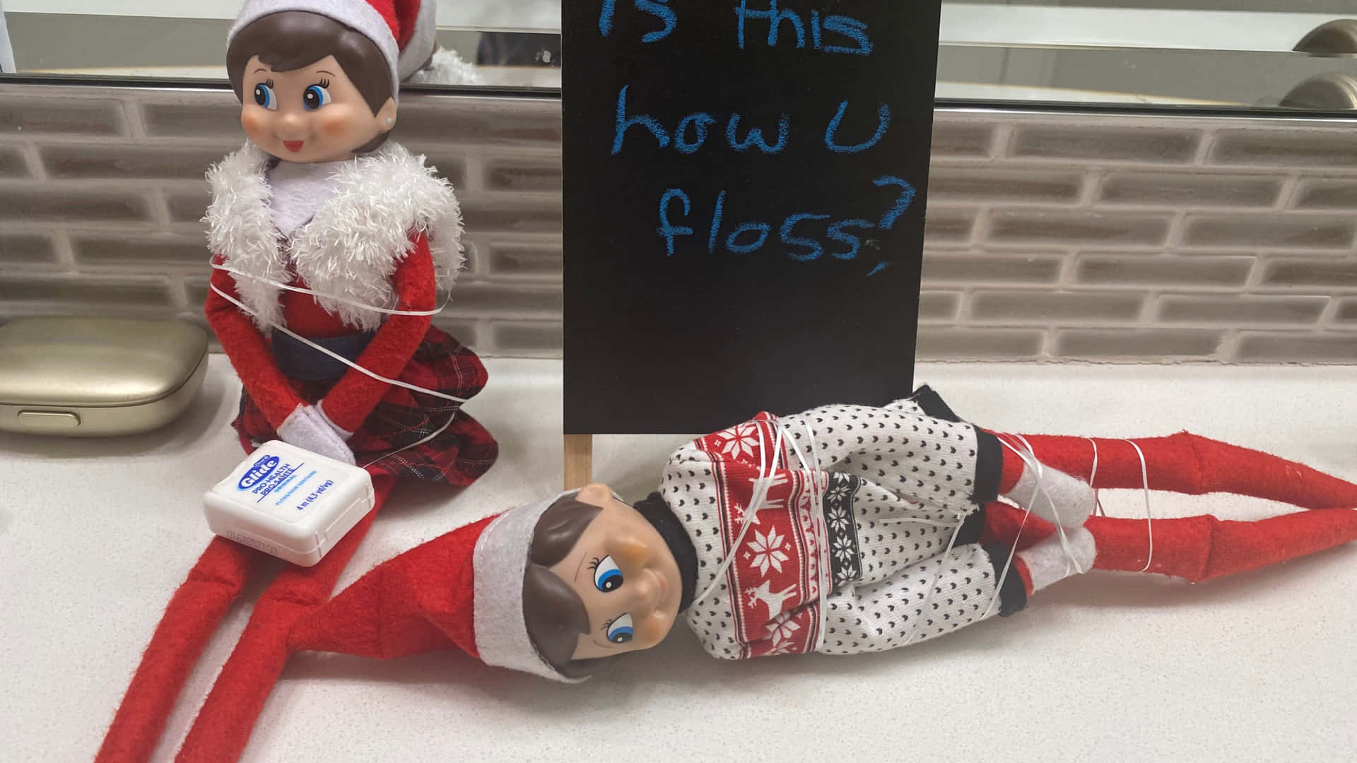 Elf On The Shelf With A Sign Saying How U Floss