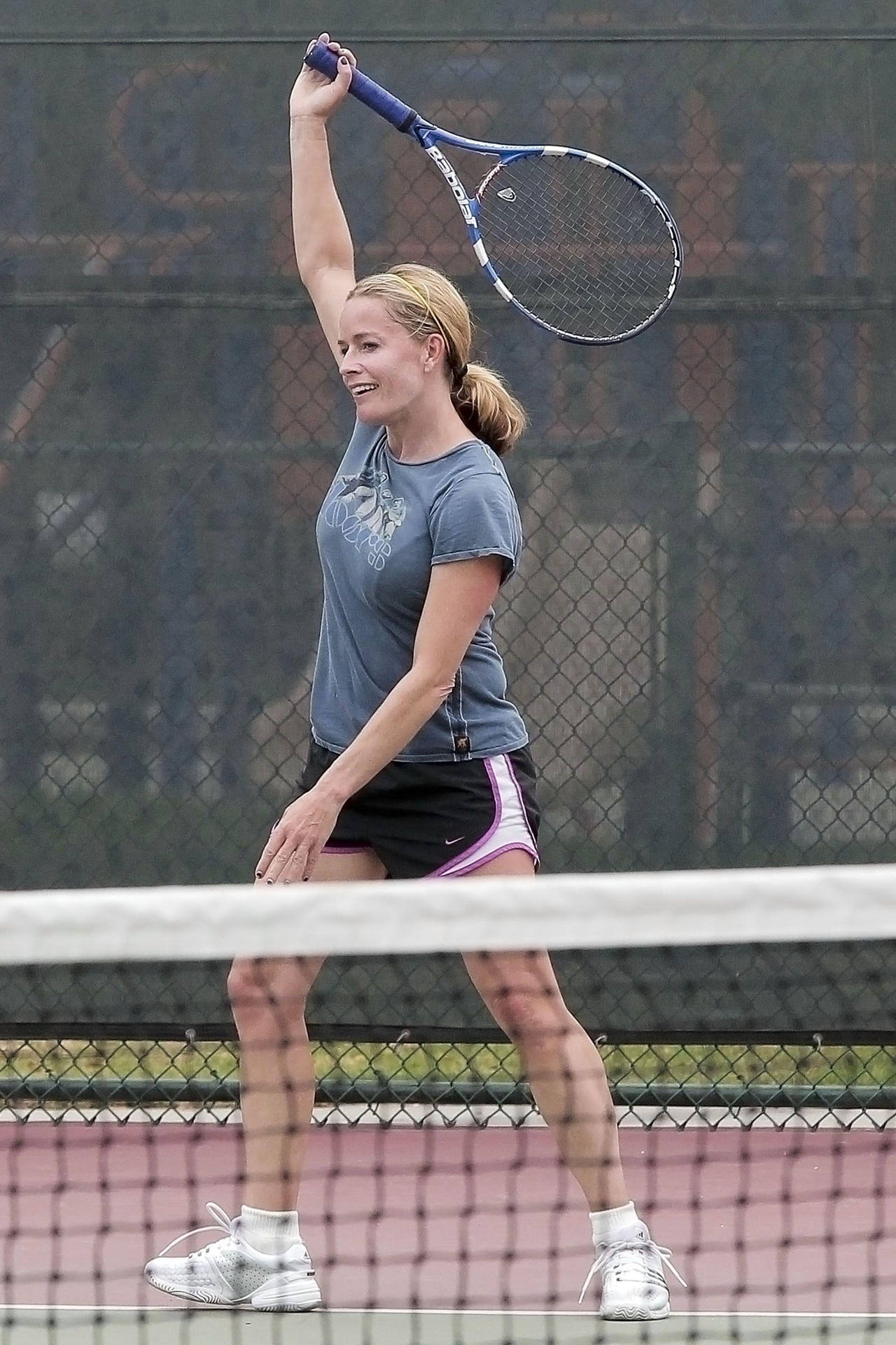 Elisabeth Shue holder tennisketcher med højre hånd i luften Wallpaper