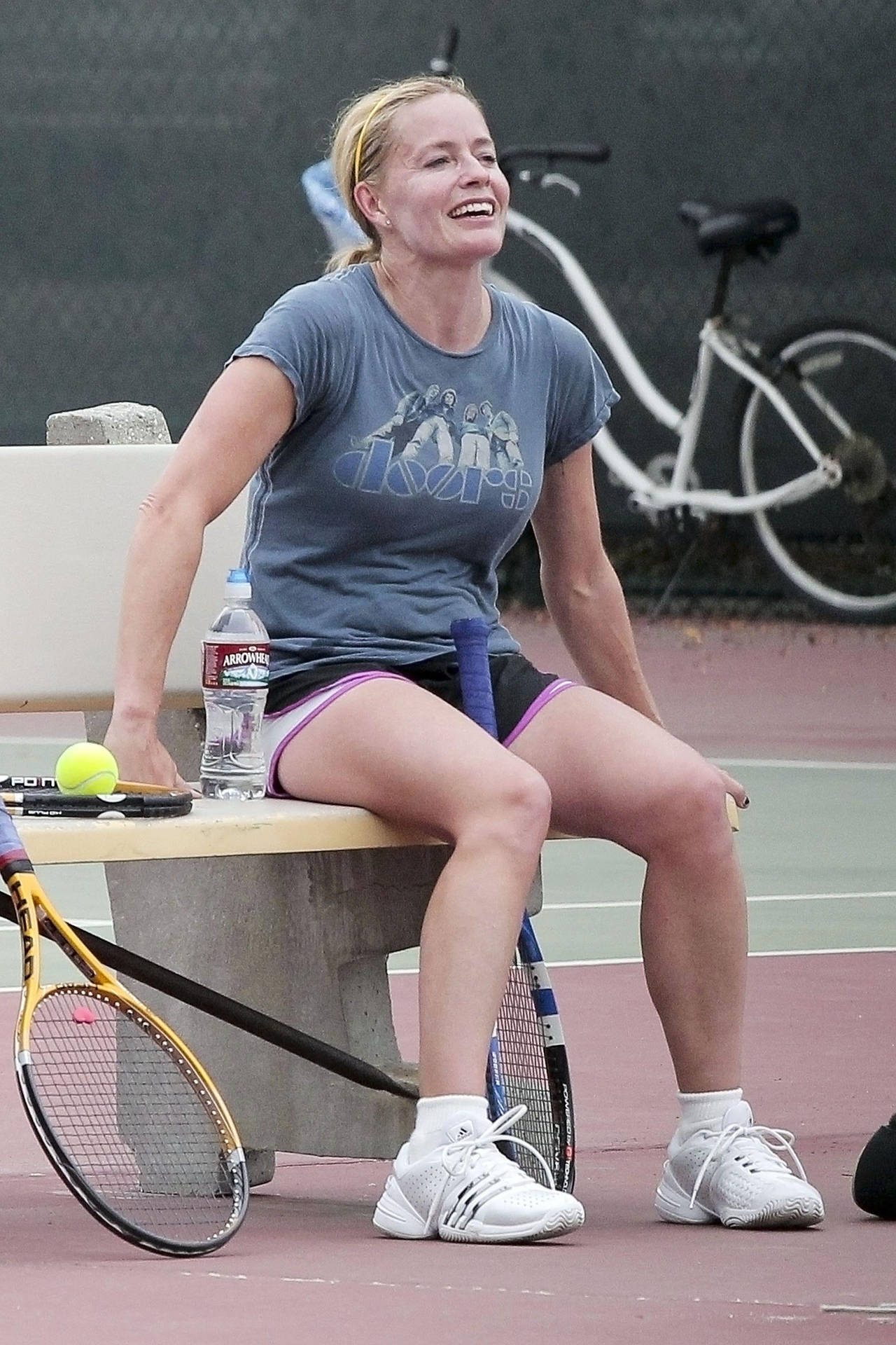 Elisabeth Shue Sitting With Tennis Racket And Smiling Background