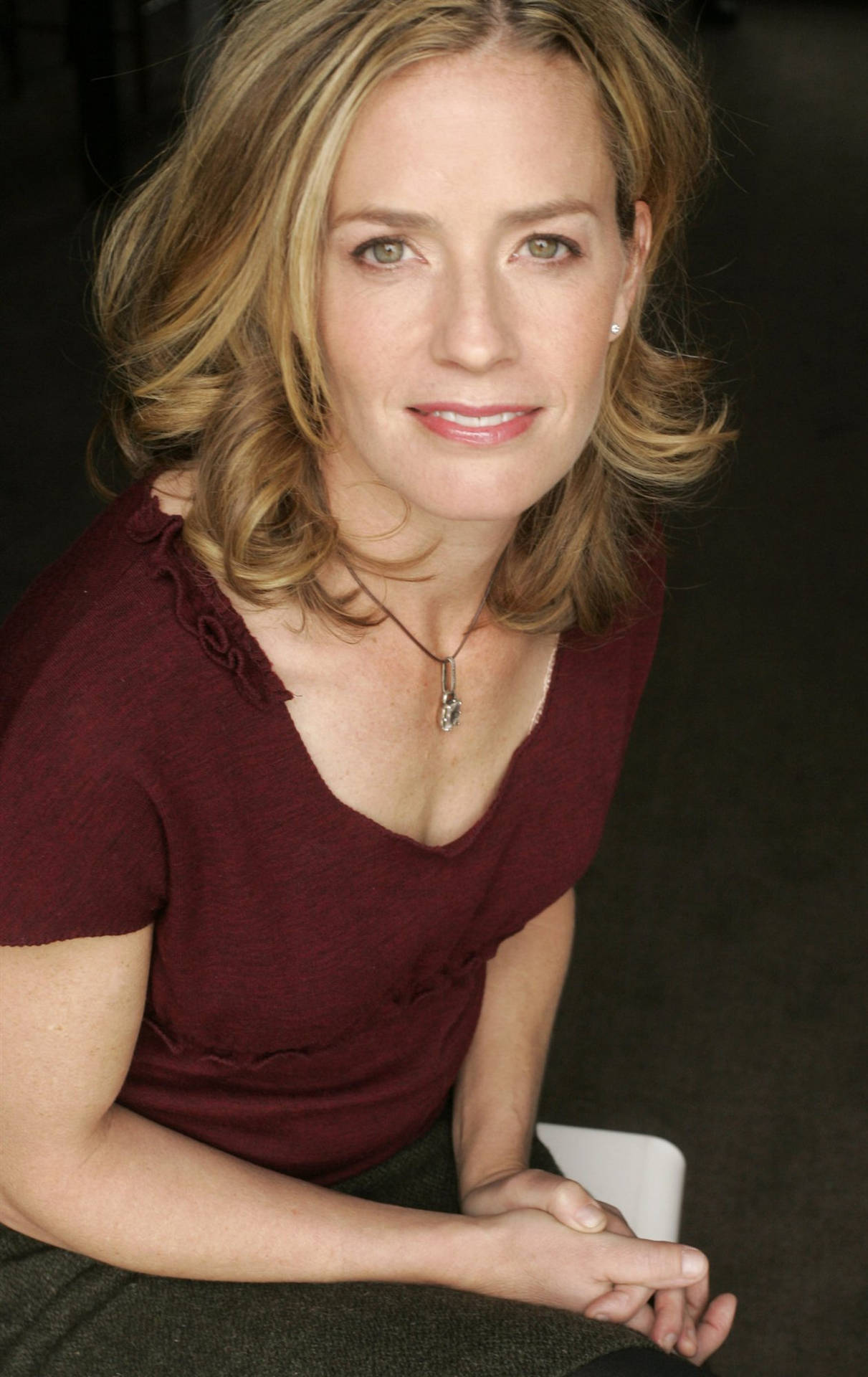 Download Elisabeth Shue Wearing Maroon Top With Both Hands On Lap Smiling  Wallpaper 