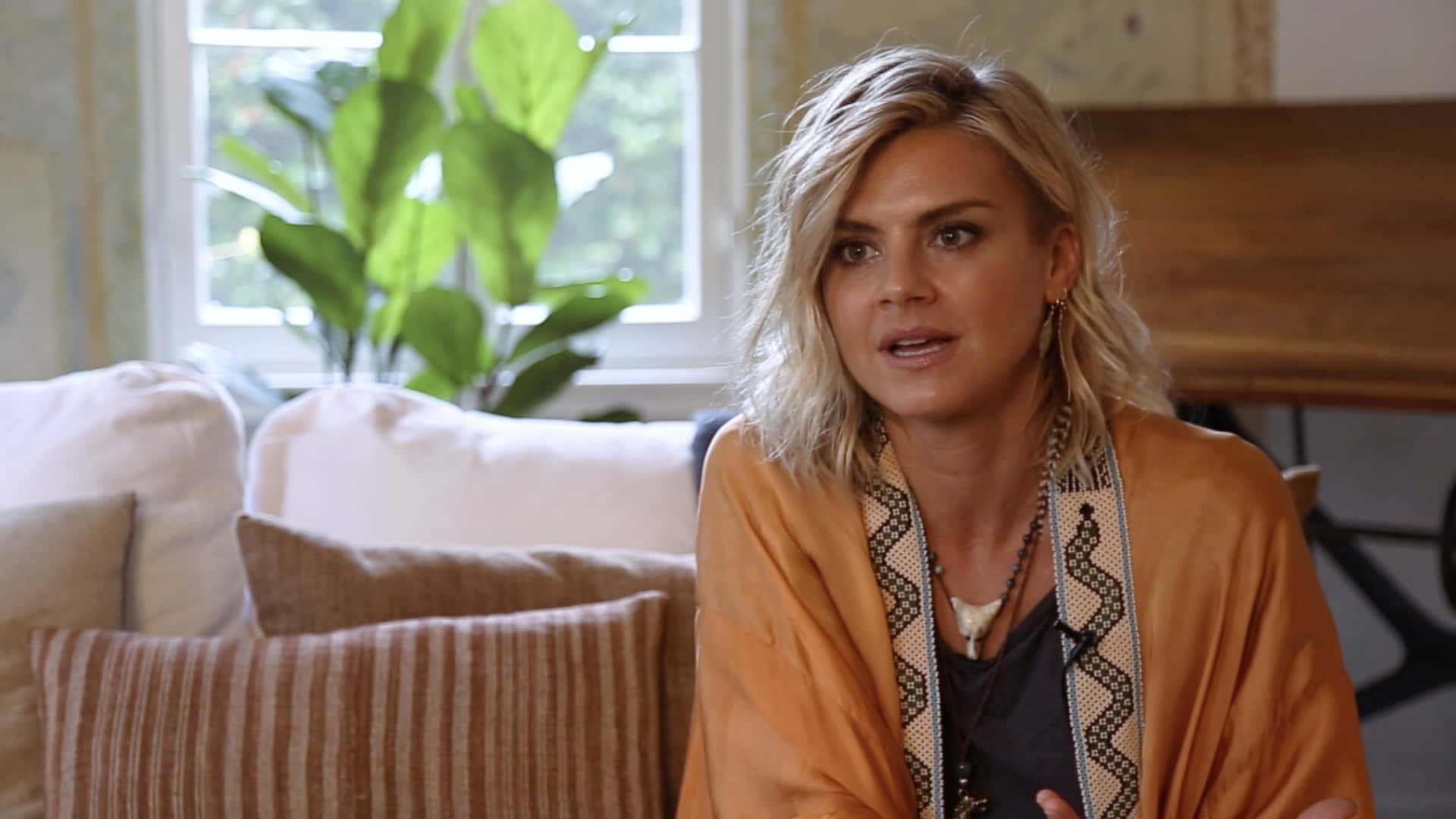 Eliza Coupe striking a pose in front of a patterned background Wallpaper