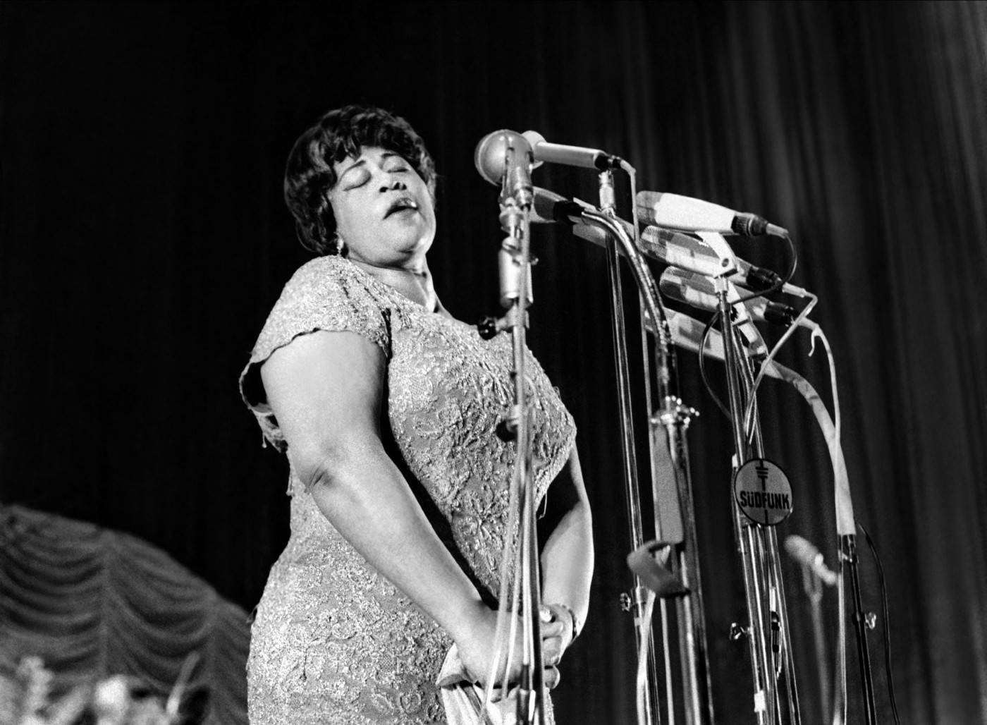 Ella Fitzgerald Multiple Microphone står på en perlegrå baggrund. Wallpaper