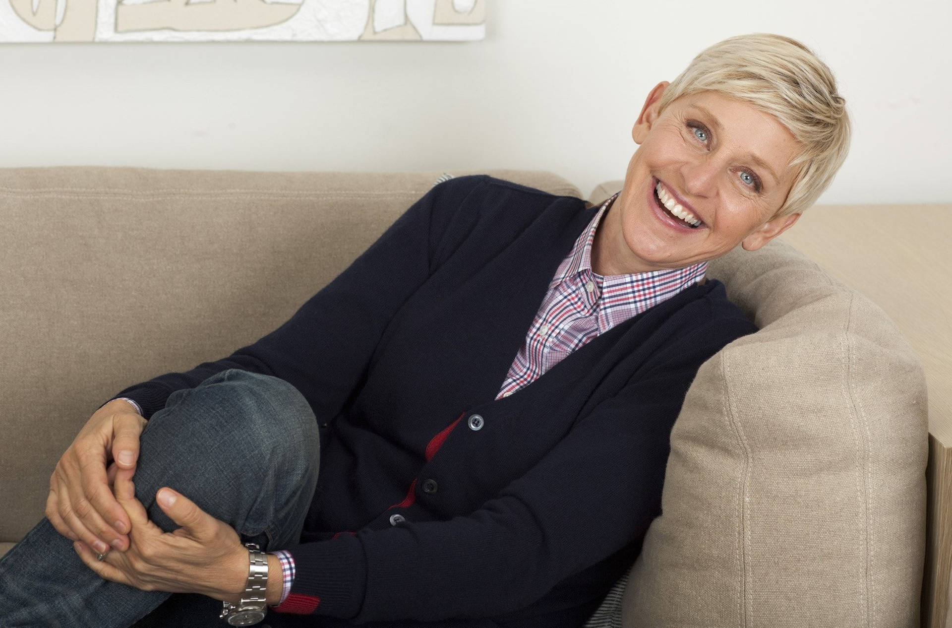 Ellen Degeneres Seated On A Couch Background