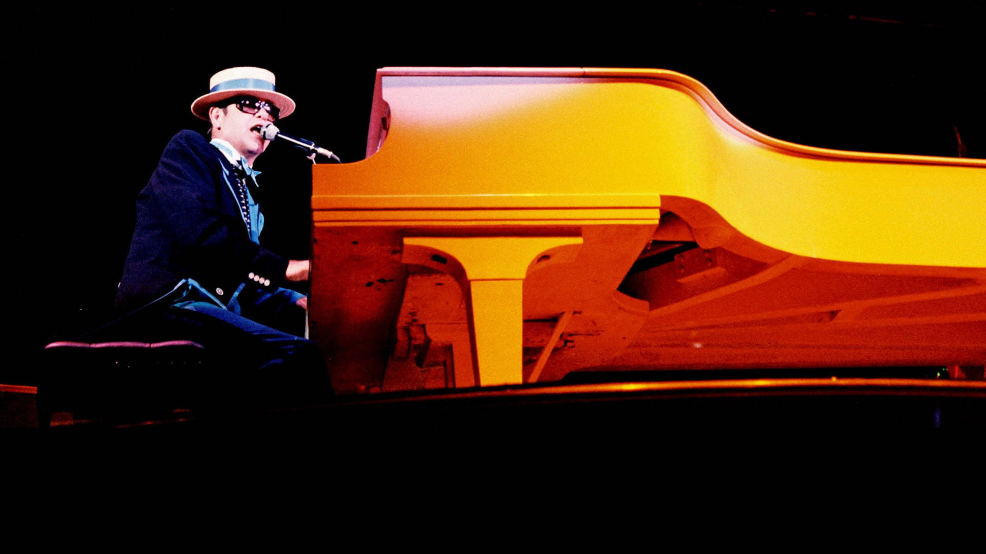 Elton John Gold Piano Koncert er en livlig blomst scenen. Wallpaper