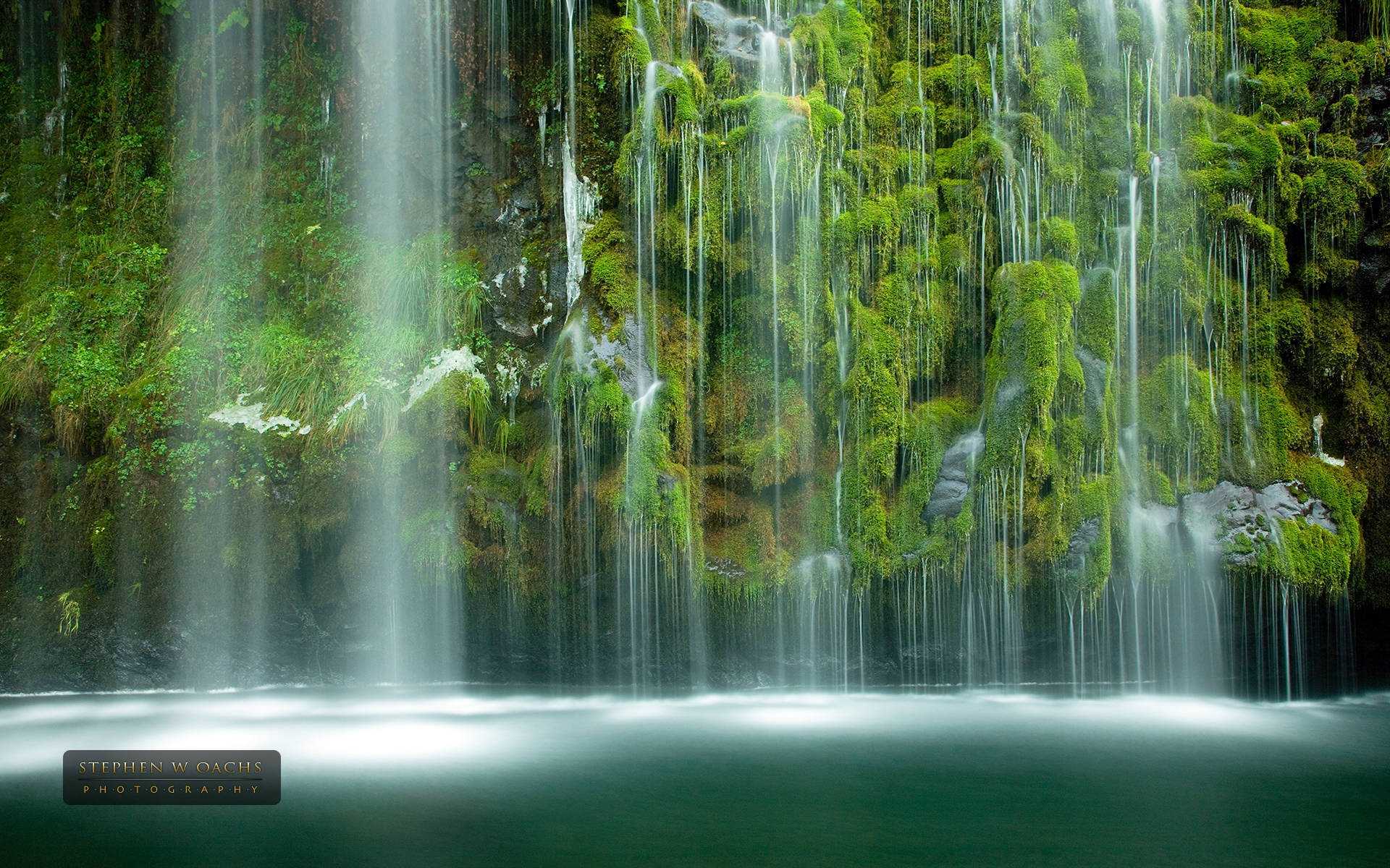 Cascadade Agua Verde Esmeralda En Medio De Árboles. Fondo de pantalla