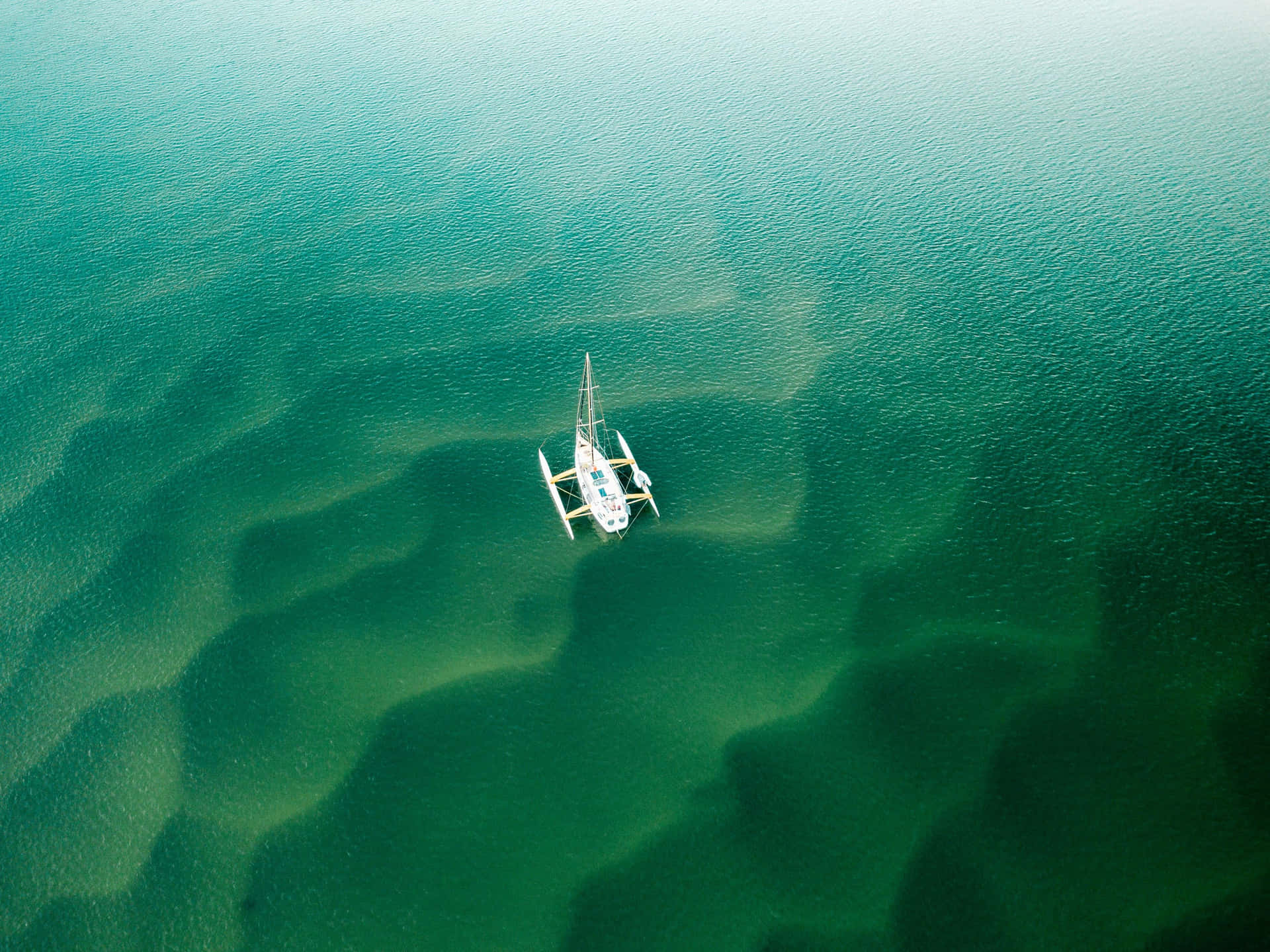 Emerald Waters Solitary Sailboat Wallpaper