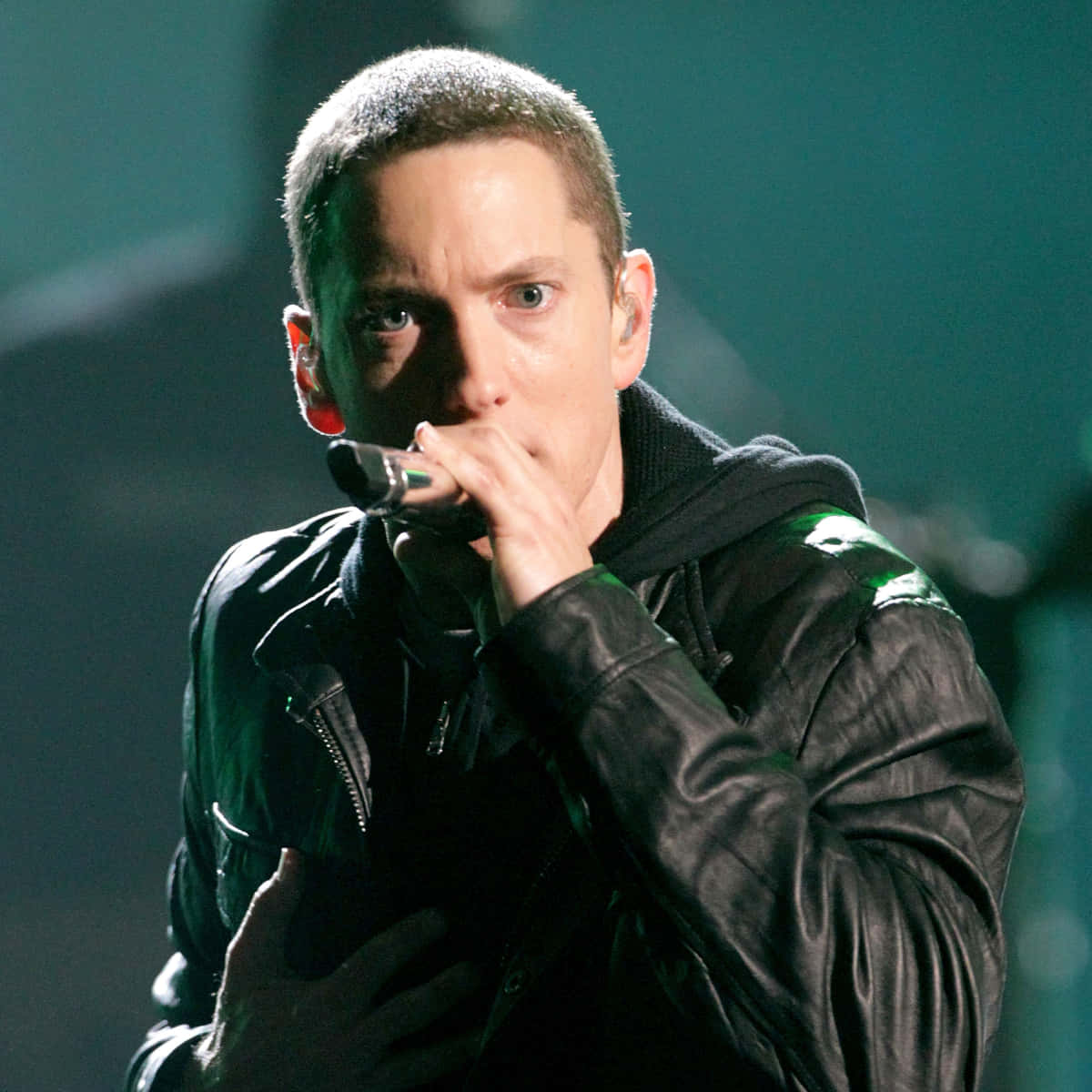 Eminem posing confidently in a black hoodie