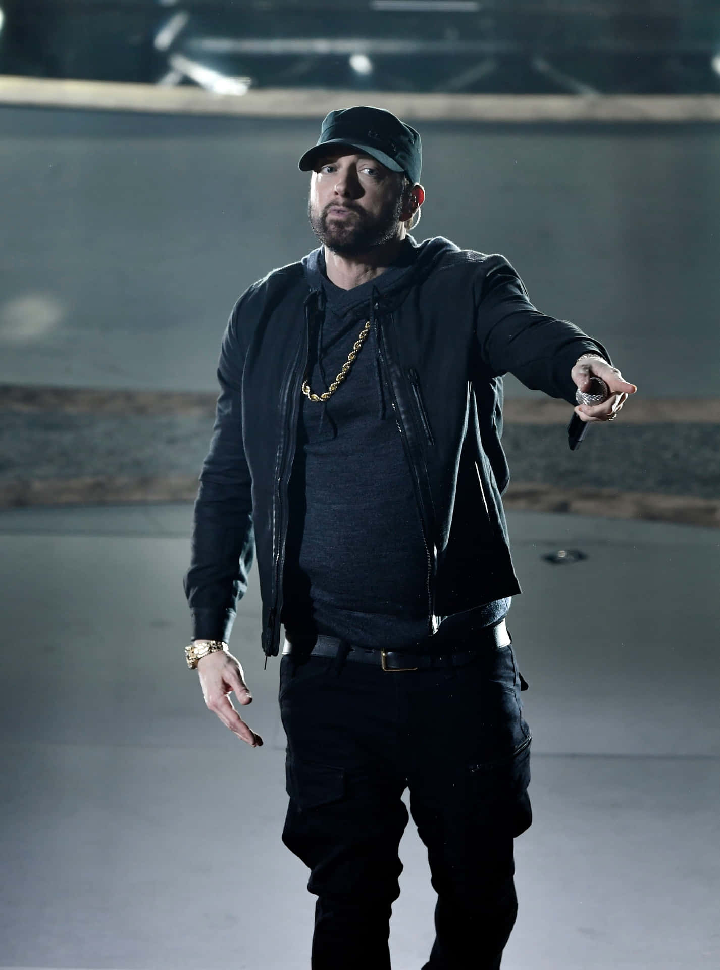 Eminem fiercely looks into the camera as he performs on stage.