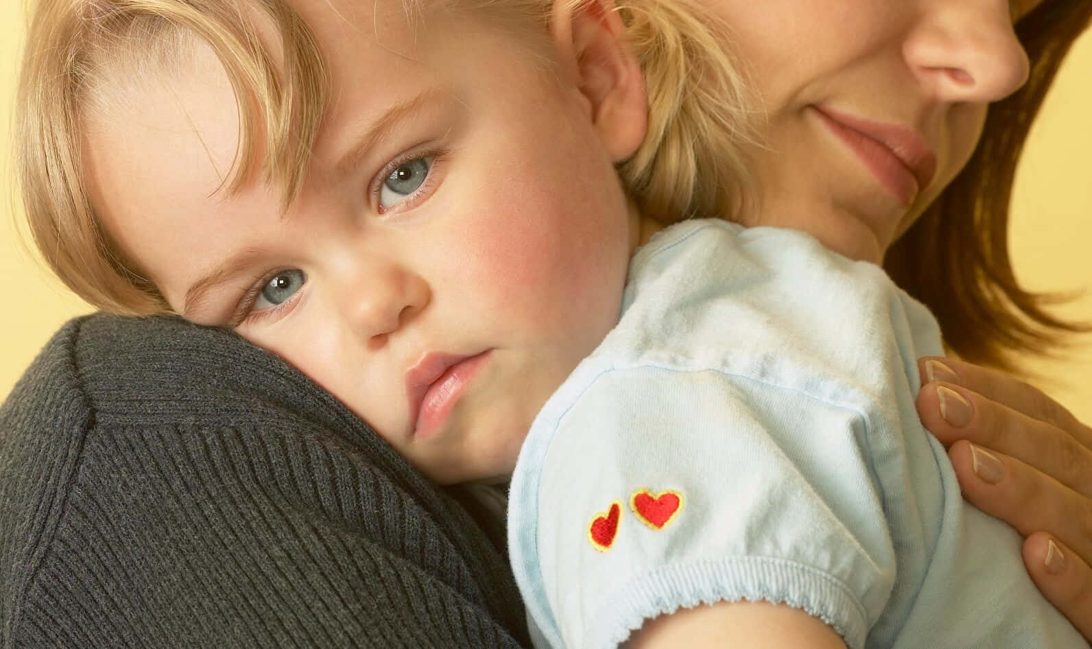 A Woman Is Holding A Child In Her Arms