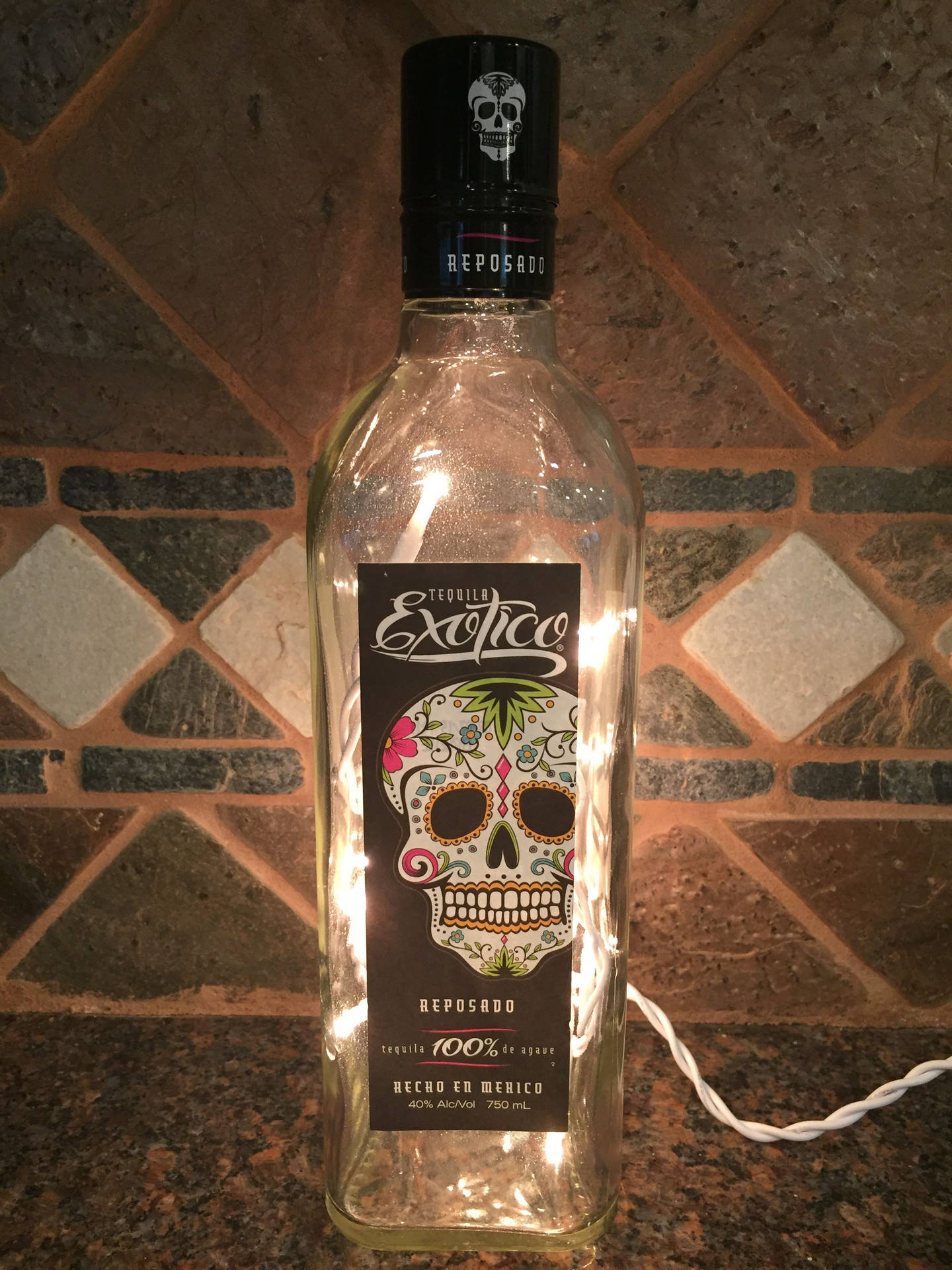 Empty Exotico Tequila Bottle With Light Wallpaper