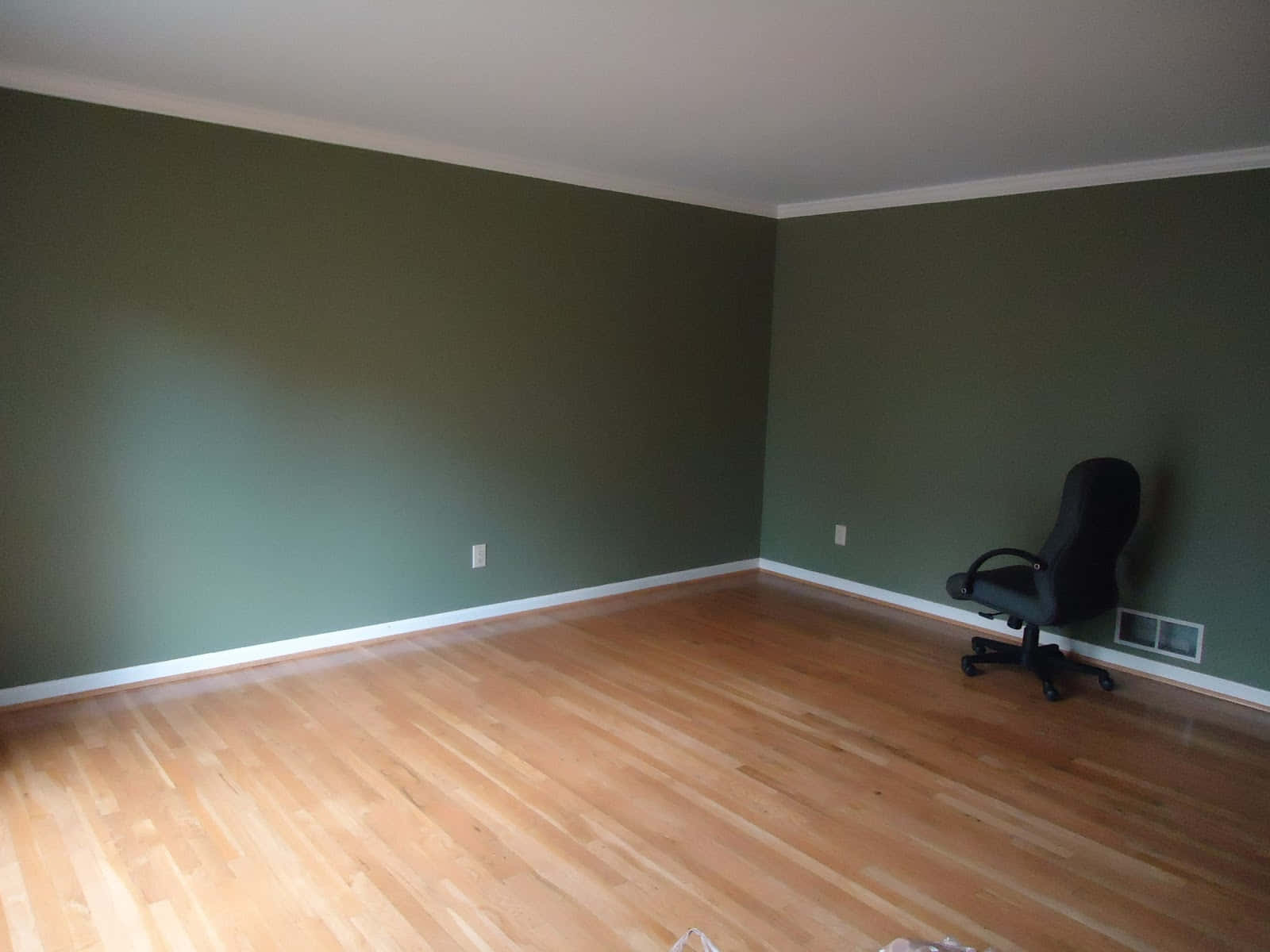 A Room With Green Walls And Hardwood Floors