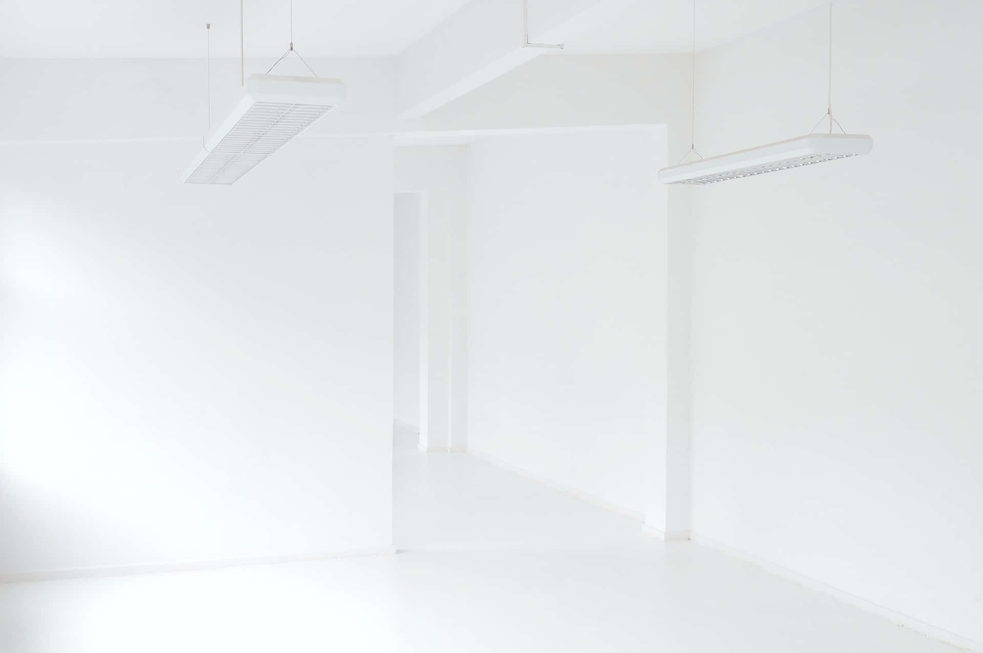 A White Room With A Few Lights Hanging Above It