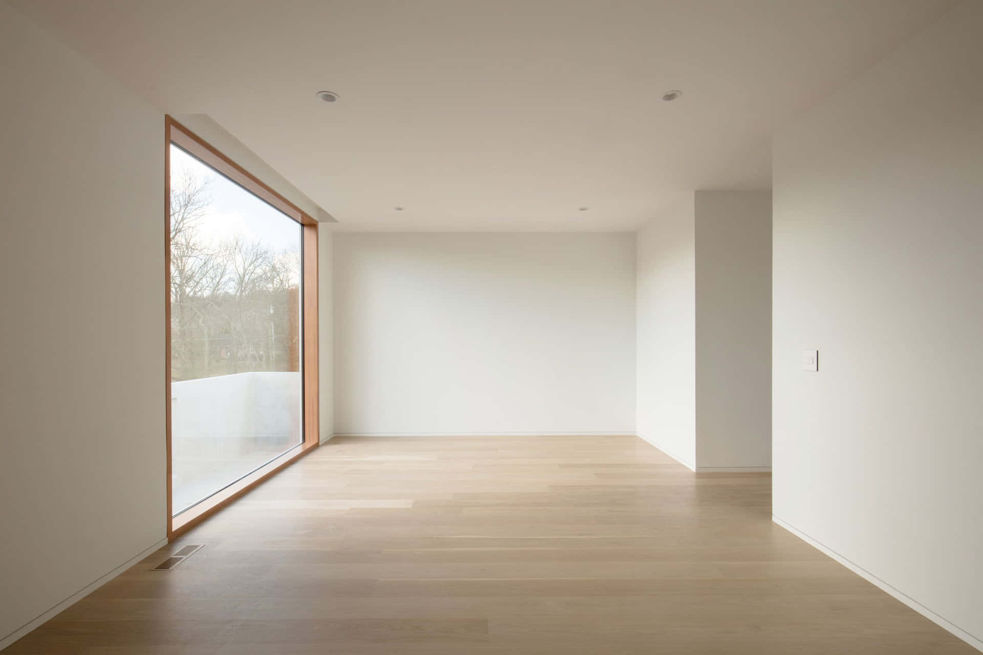 A Room With White Walls And Wood Floors