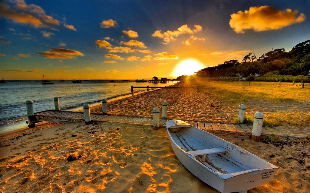 Enchanting Golden Sunset Skyline Over The Calm Ocean Wallpaper