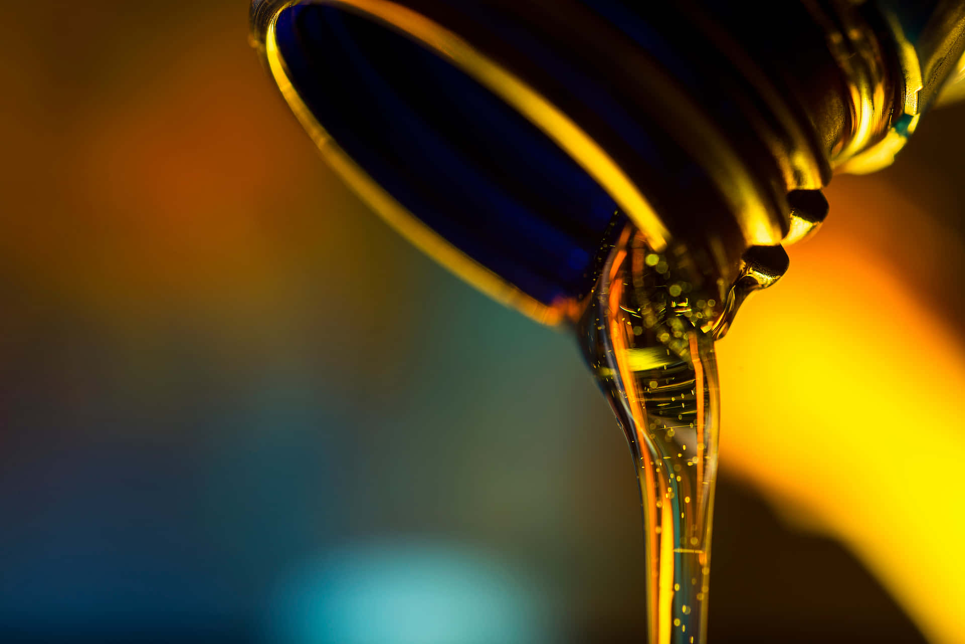 A Bottle Of Oil Is Being Poured Into A Glass