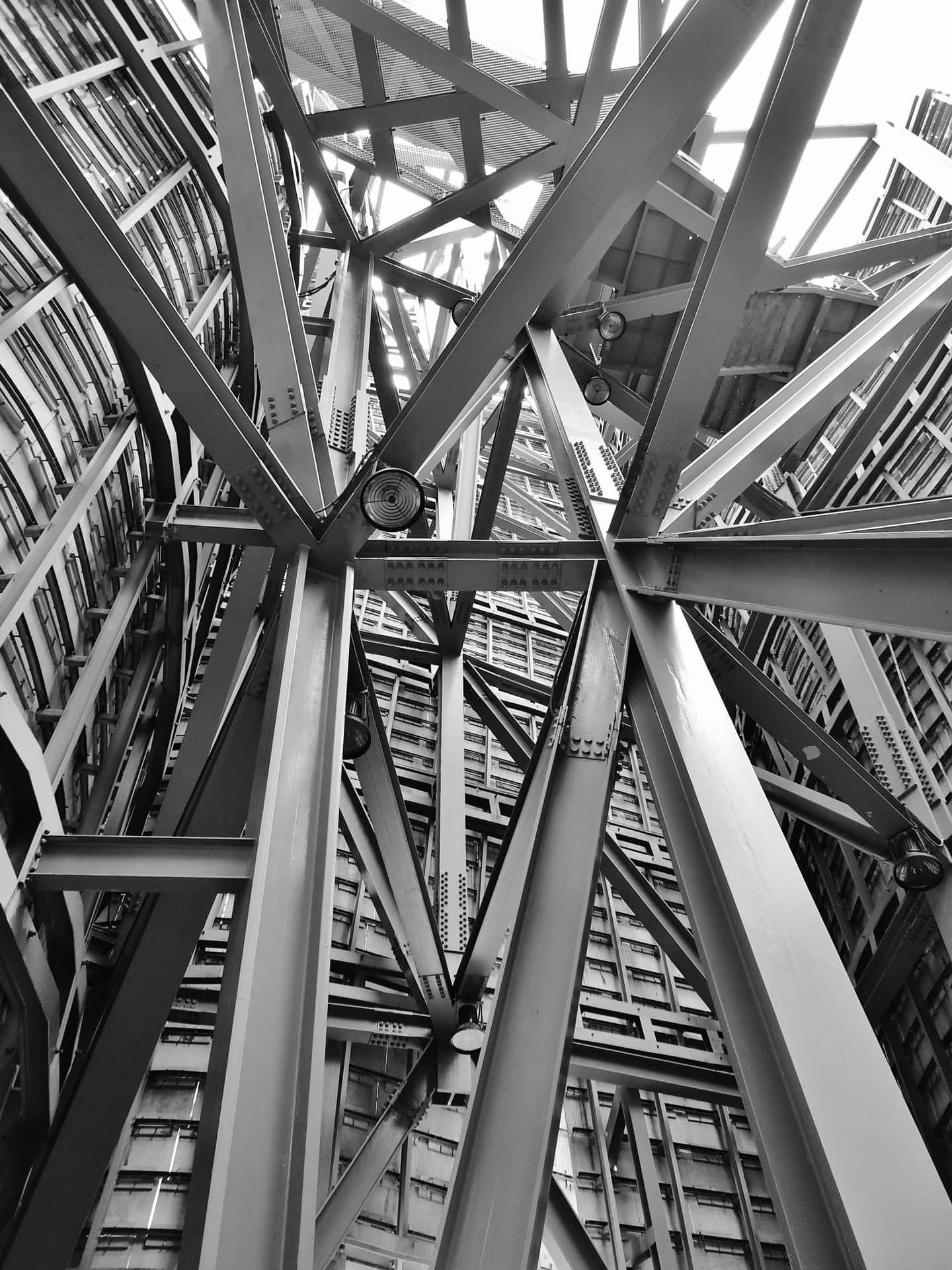 A Black And White Photo Of A Building With Metal Structures
