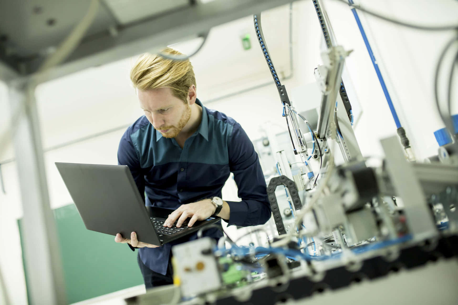 A Man Working On A Laptop In A Machine Shop