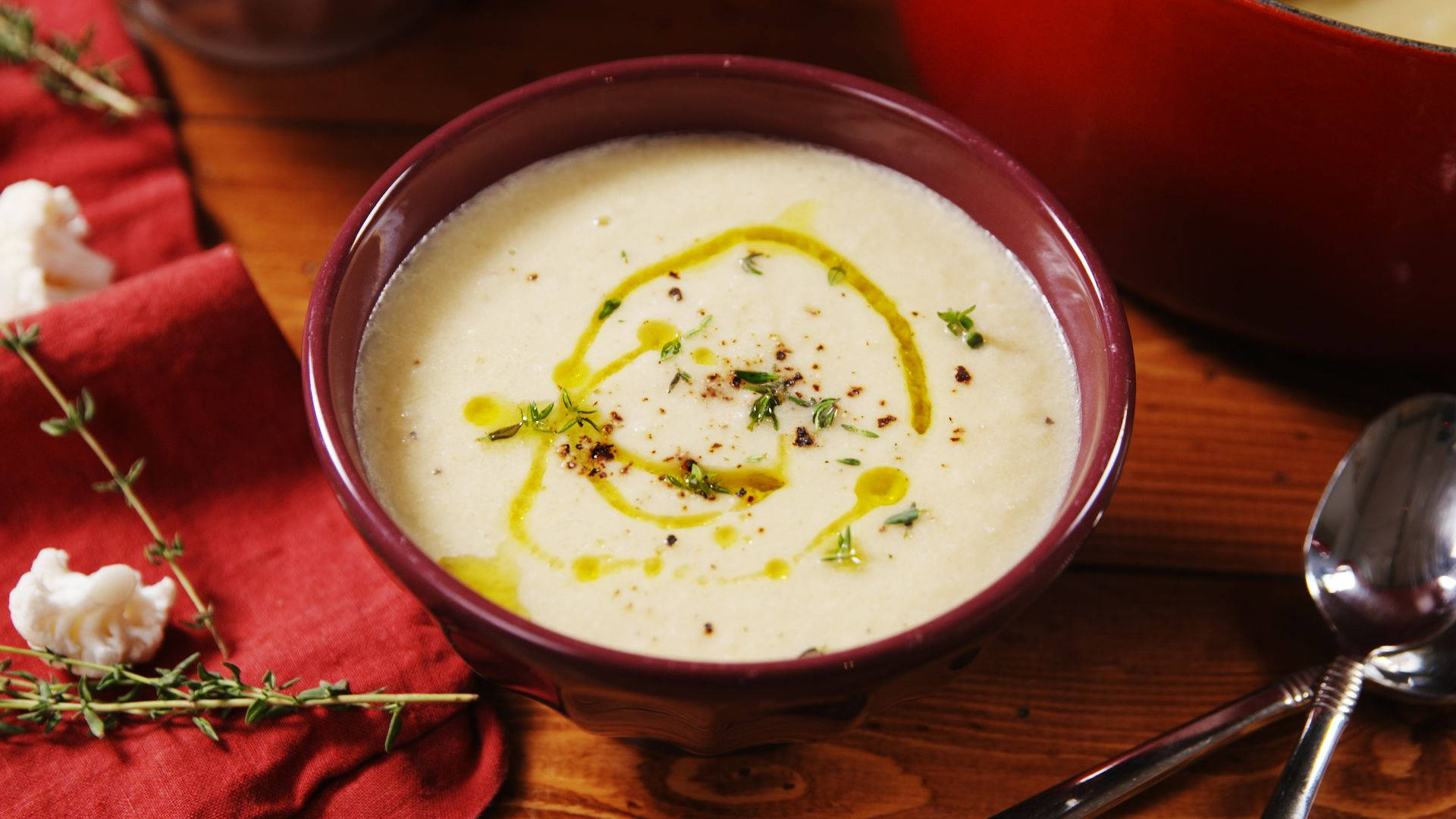 A wholesome bowl of Cauliflower Soup in a red bowl. Wallpaper